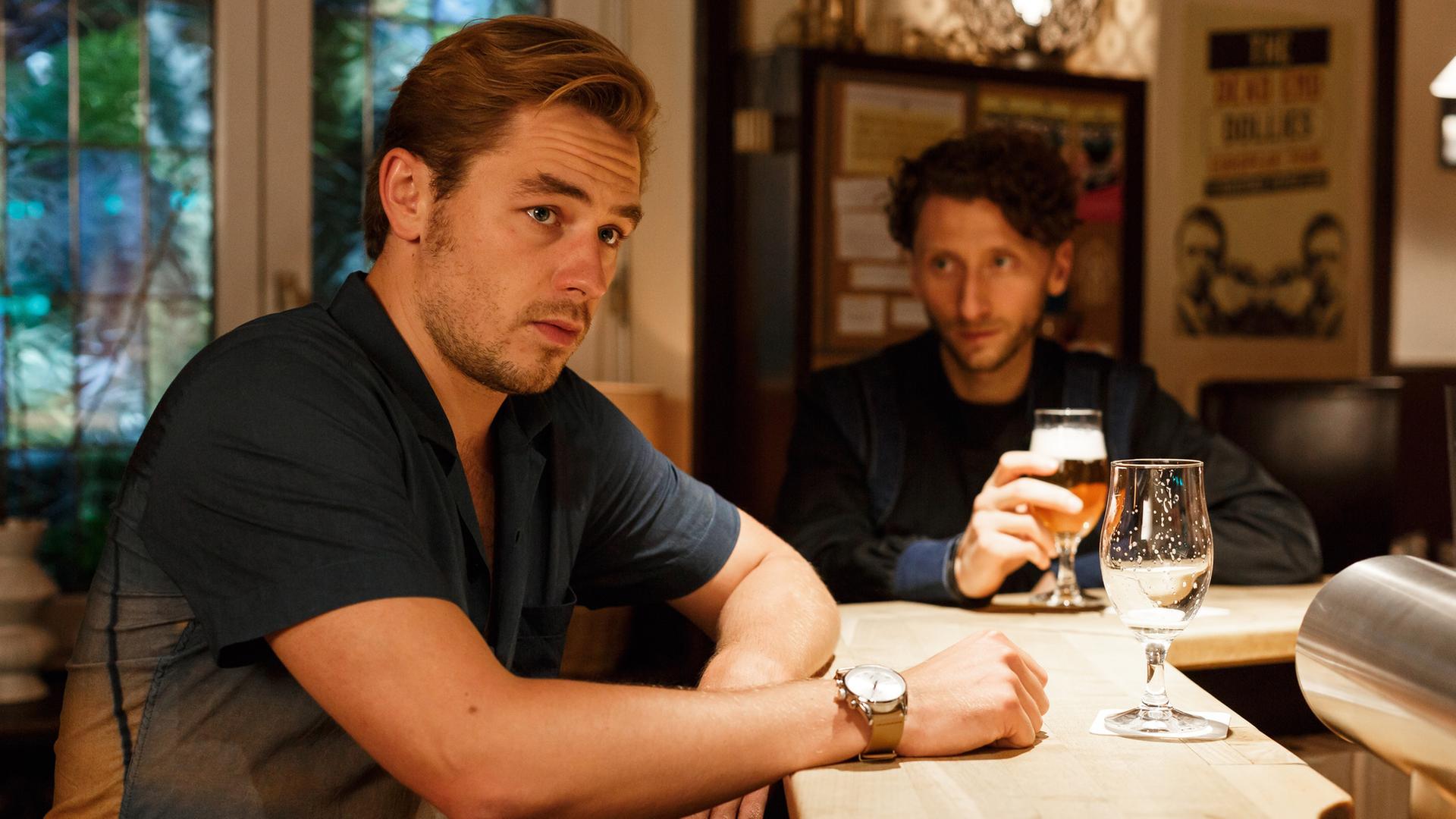 "Bettys Diagnose - Plan B": Lukas (Niklas Löffler) sitzt mit seinem Kumpel Chris Kuper (Moritz Heidelbach) in Safis Kneipe am Tresen. Lukas schaut gedankenverloren vor sich hin.