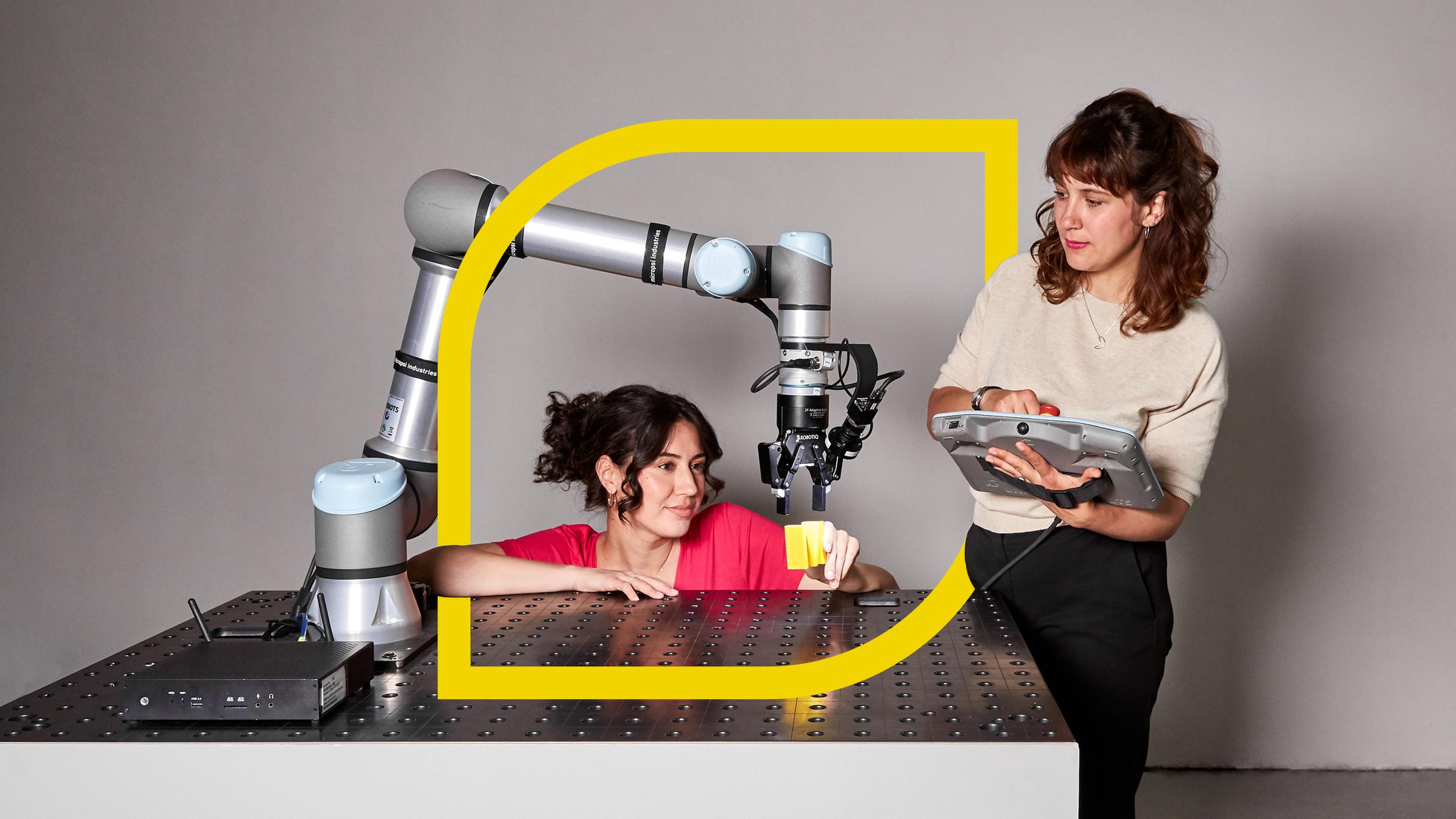  Refiye Ellek (l.) und Antonia Lilly Schanze (r.) testen einen Roboterarm.