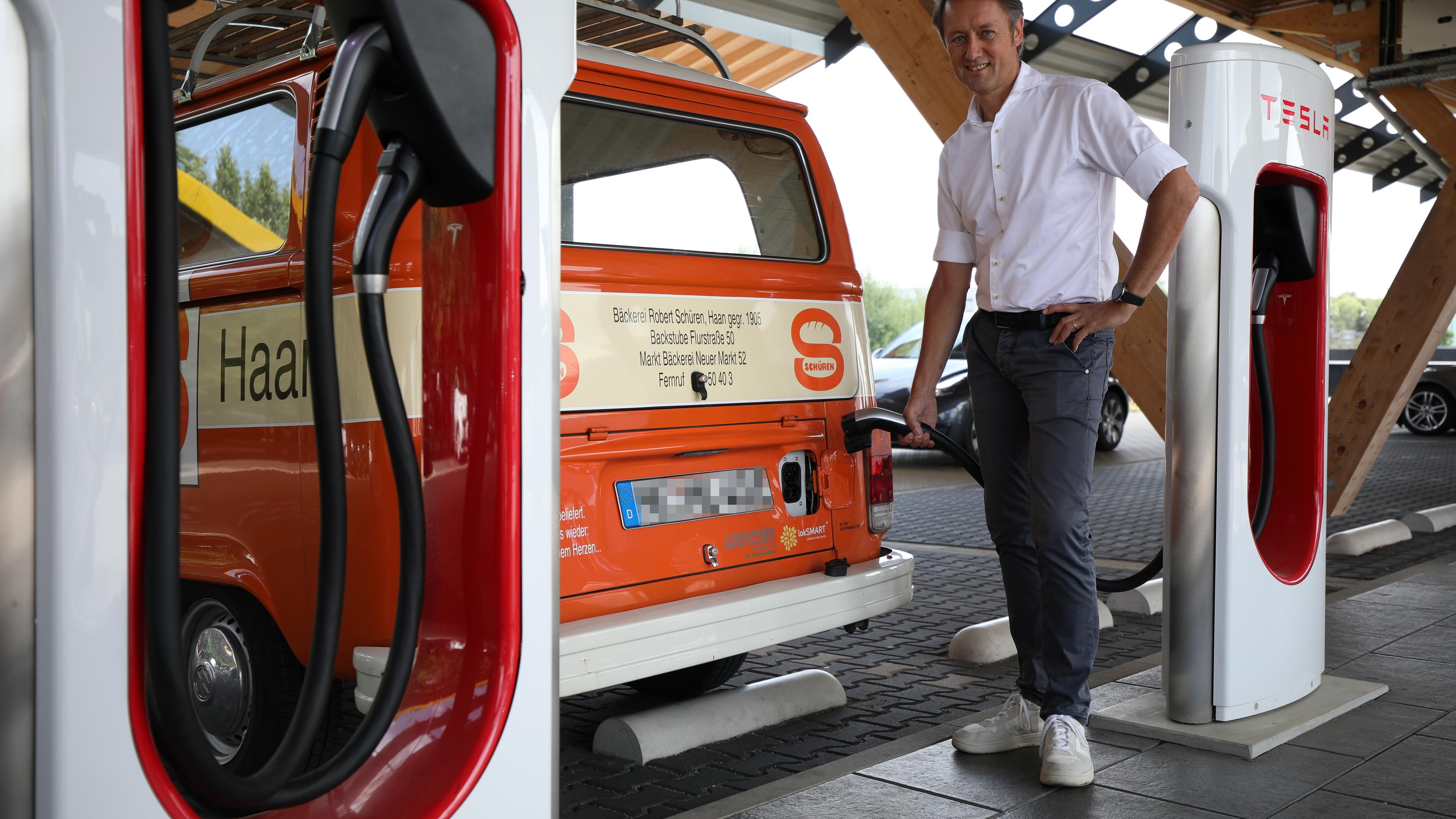 Roland Schüren lädt an einer Ladestation für E-Autos seinen Elektro-Bus.