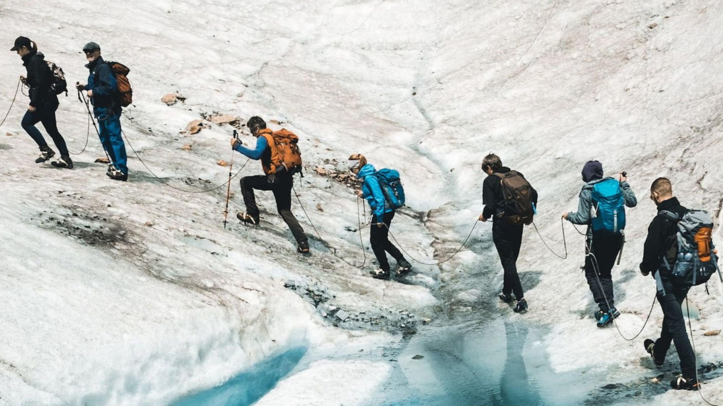 Blick von oben auf eine Wandergruppe, die über den Aletschgletscher in der Schweiz läuft