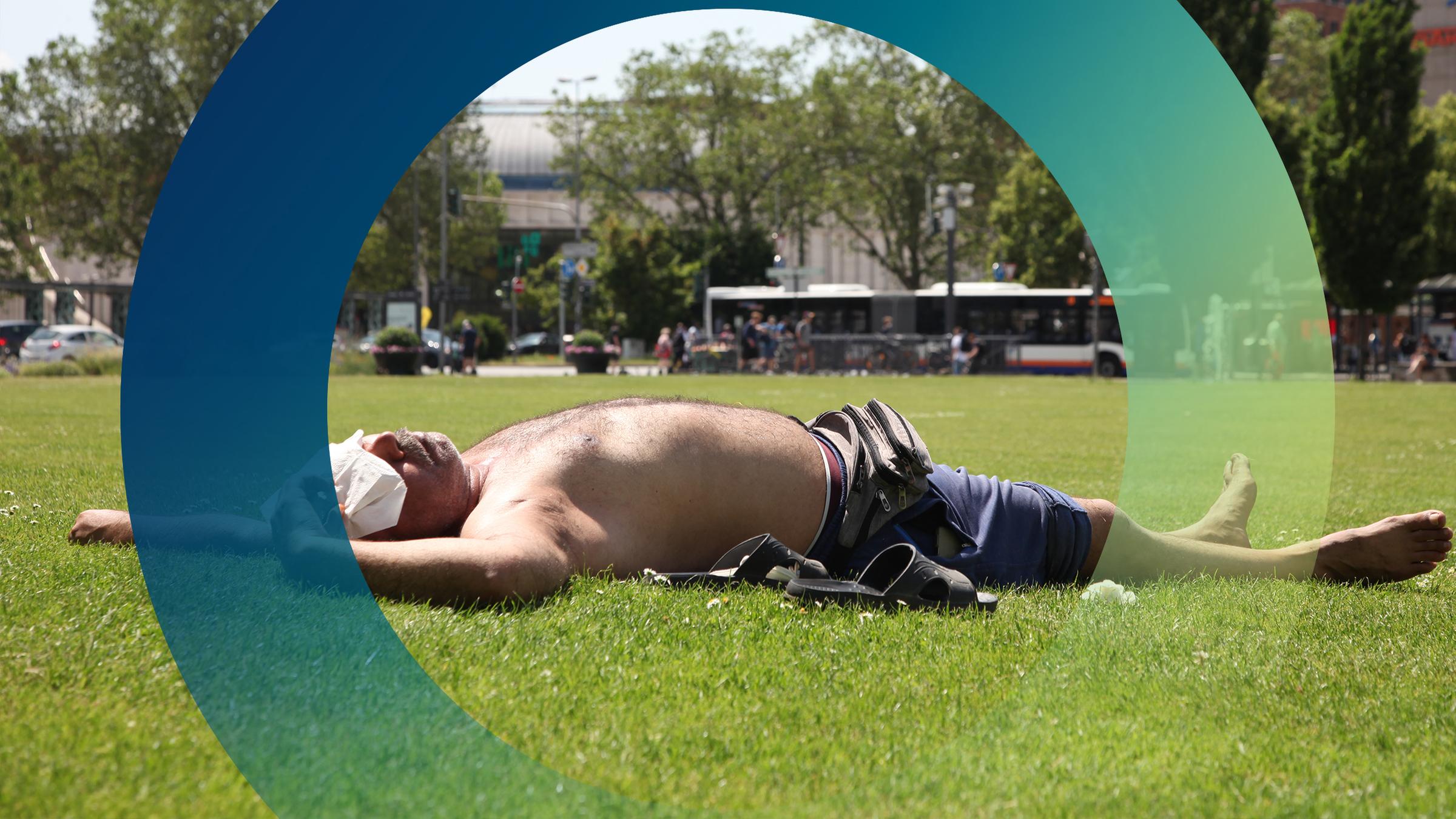 Mann liegt mit bloßem Oberkörper bei sommerlicher Hitze auf einer Wiese mitten in der Stadt