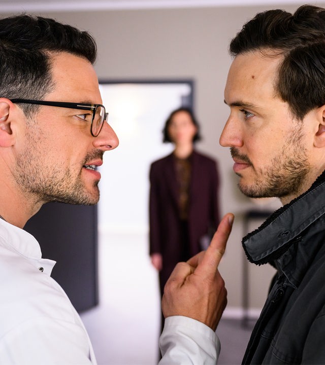 "Bettys Diagnose - Plötzlich Familie": Dr. Tom Koopmann (Tobias Licht) droht mit dem Zeigefinger seinem Bruder Mirko Koopmann (Tobias van Dieken). Diese Szene beobachtet die hiereinkommende Haruko Wedekind (Agnes Decker).