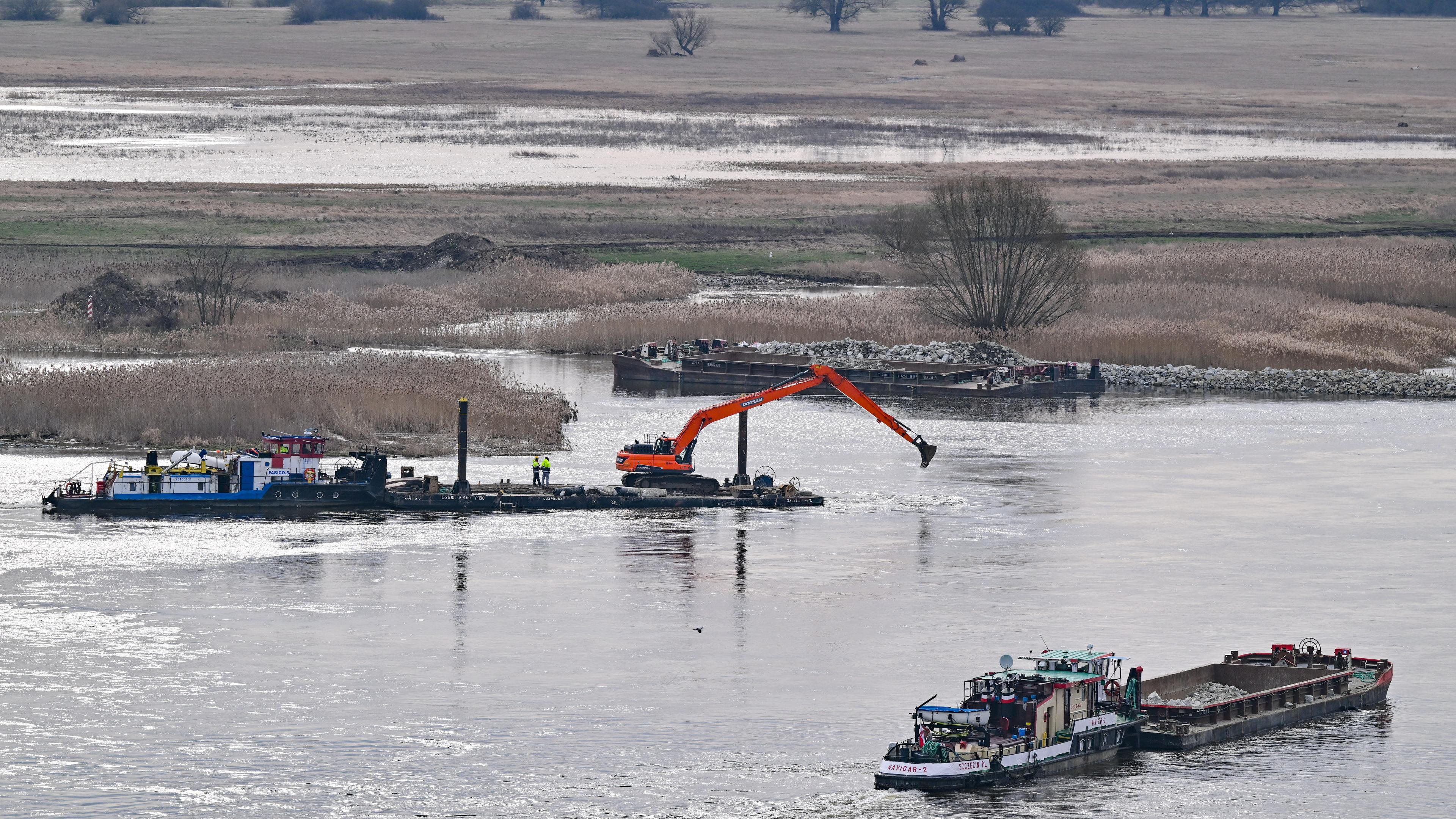 Schiffe und Baumaschinen zum Ausbau des deutsch-polnischen Grenzflusses Oder arbeiten auf der polnischen Uferseite.