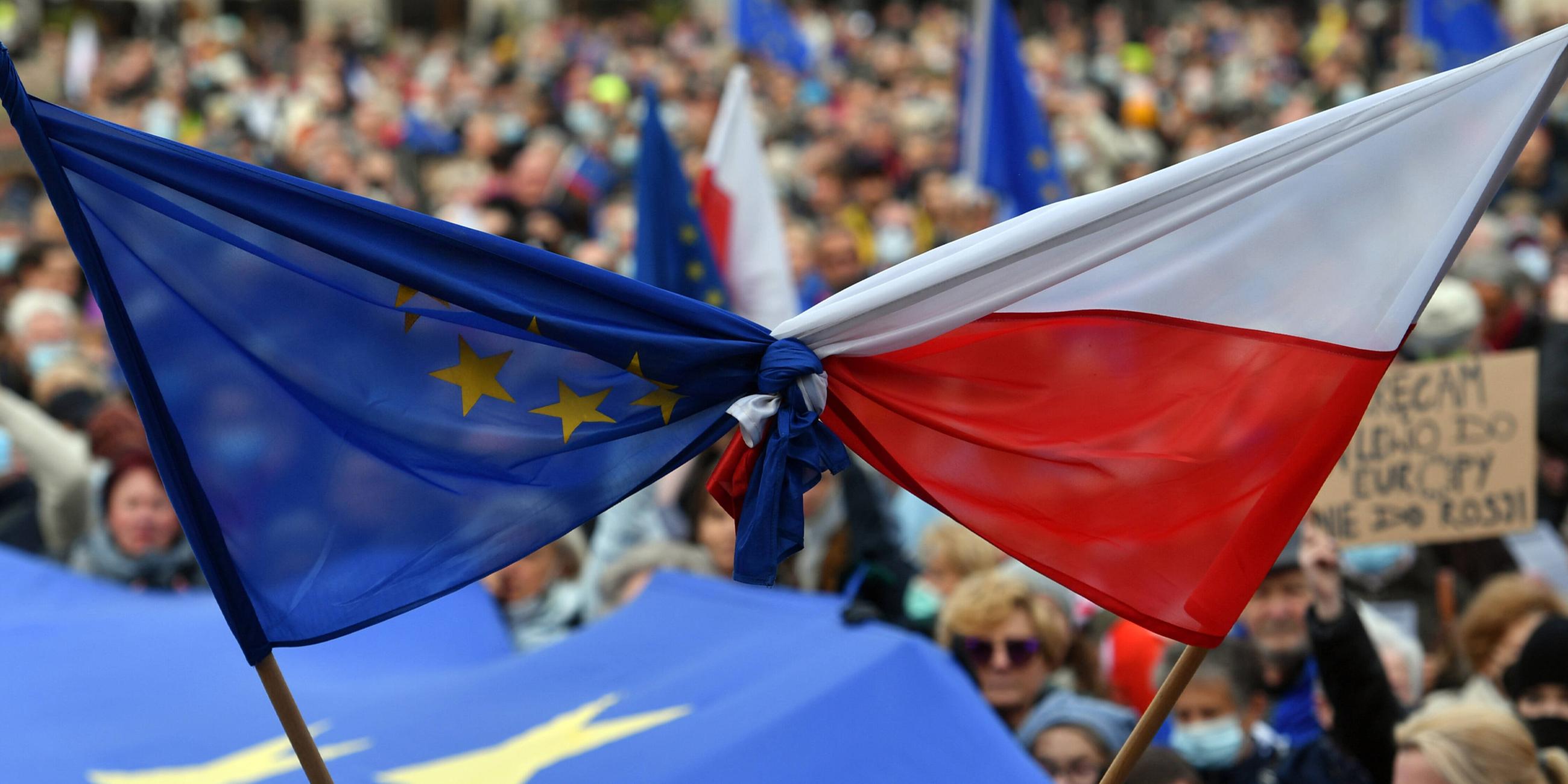 Demonstranten halten gebundene Flaggen der Europäischen Union und Polens während der Demonstration am 10.10.2021.