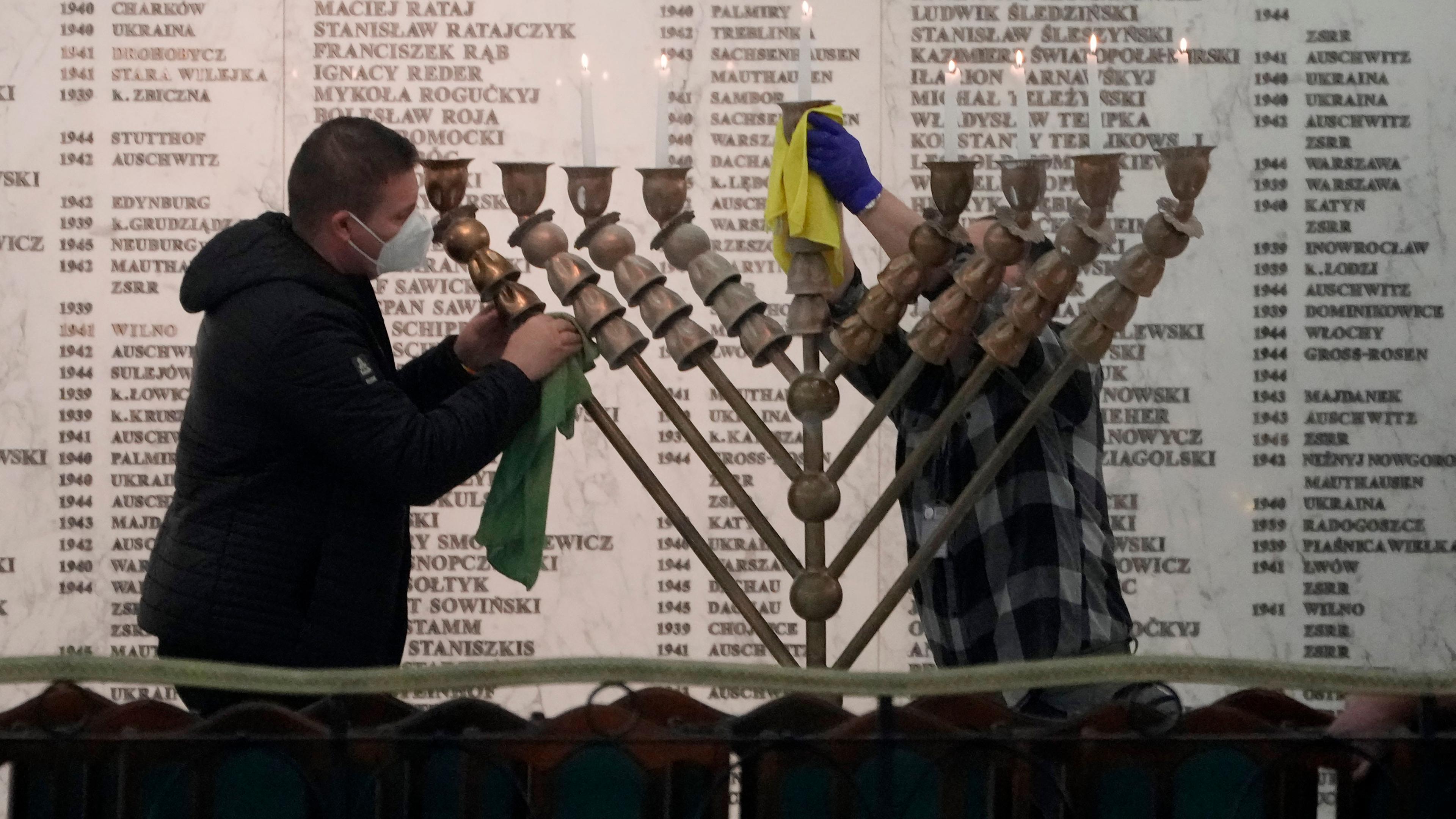 Polen, Warschau: Zwei Männer reinigen im polnischen Parlament eine Menora, nachdem ein rechtsextremer Abgeordneter einen Feuerlöscher genommen und eine Kerze gelöscht hat, um die Feier des jüdischen Feiertags Channuka zu stören.