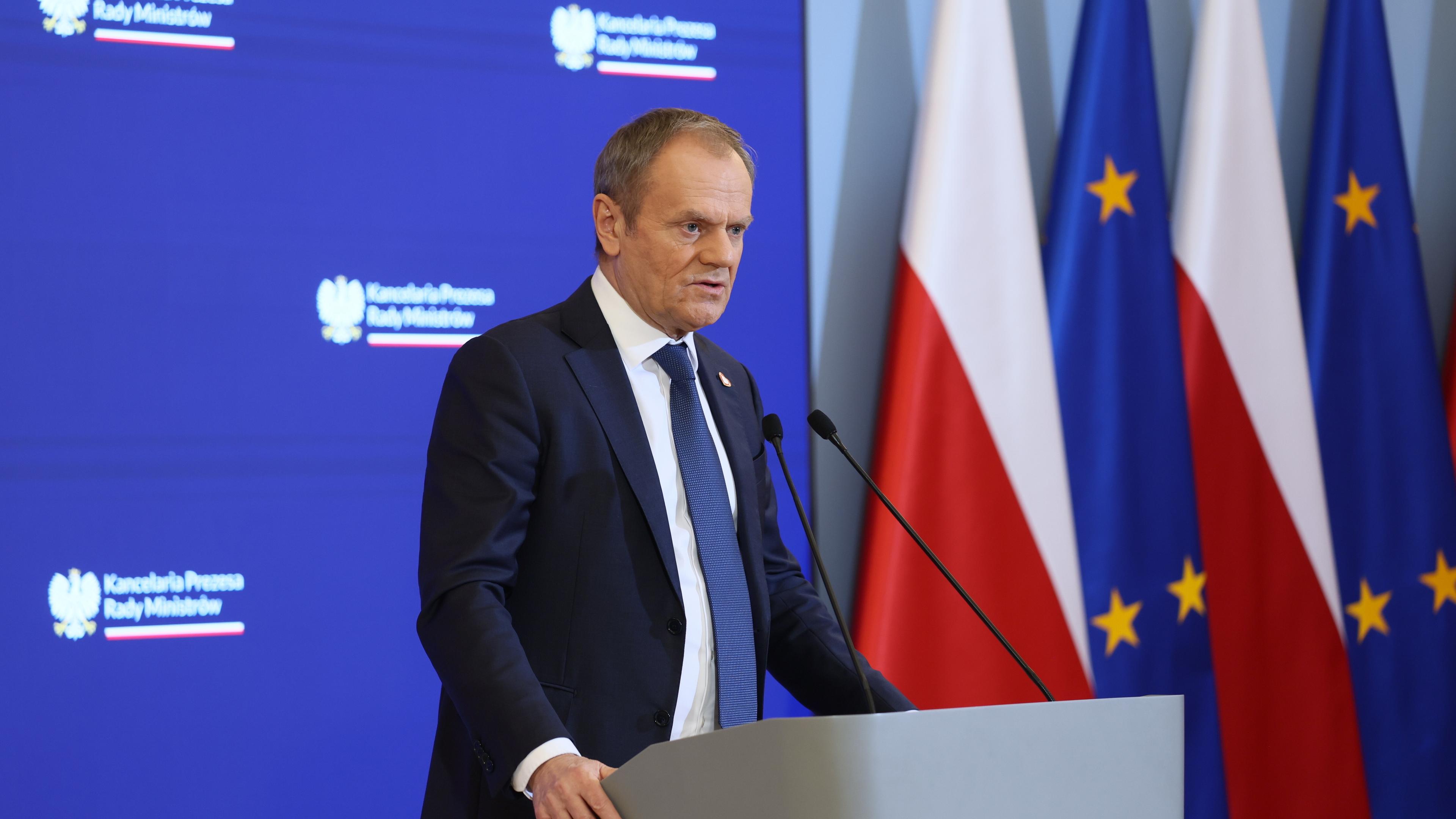 Polens Ministerpräsident Tusk gestern bei einer PK. Im Hintergrund die Flaggen Polens und der EU.