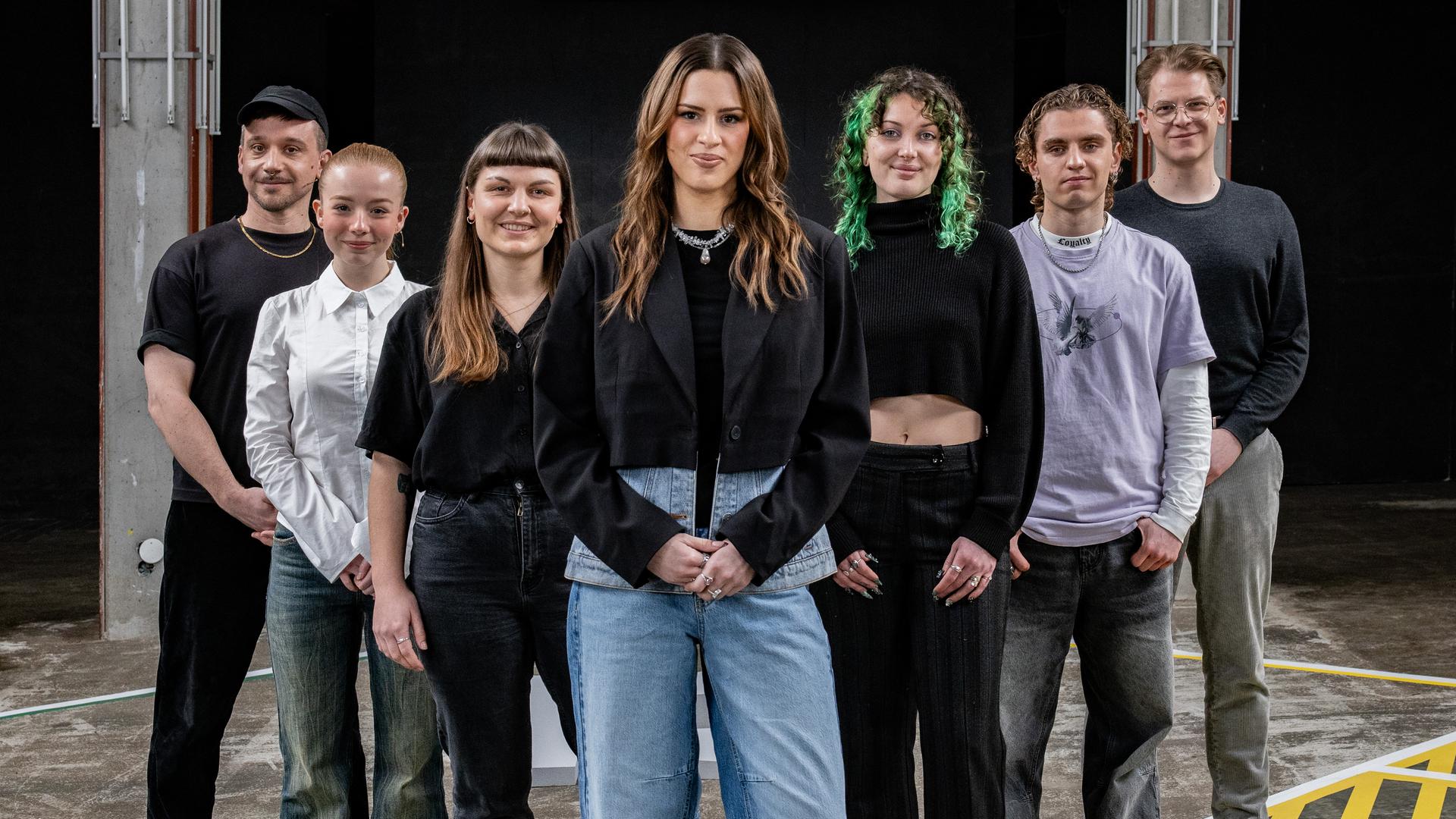 Moderatorin Salwa Houmsi steht mit ihren sechs Gästen auf dem 13-Fragen-Spielfeld.