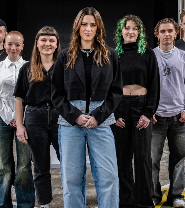 Moderatorin Salwa Houmsi steht mit ihren sechs Gästen auf dem 13-Fragen-Spielfeld.