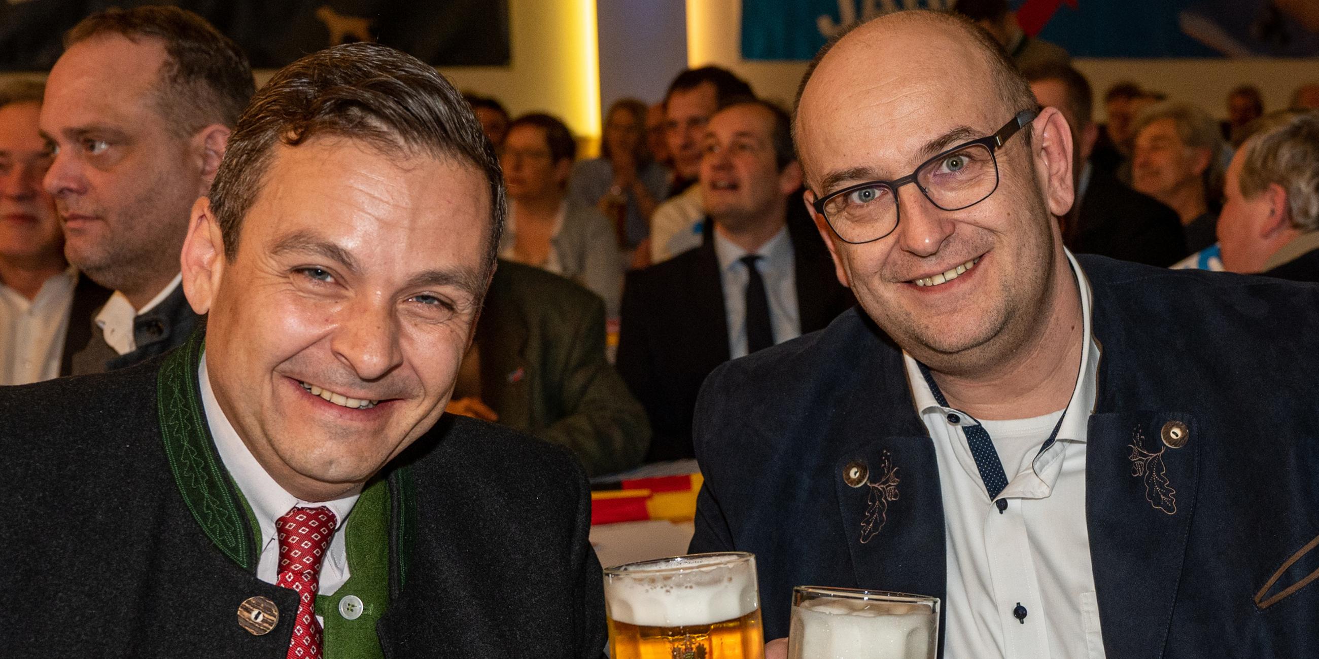 Stephan Protschka (r), Landesvorsitzender der bayerischen AfD, prostet beim Politischen Aschermittwoch der Alternative für Deutschland (AfD) neben Gerald Grosz, Publizist und Präsidentenkandidat aus Österreich, mit Biergläsern.