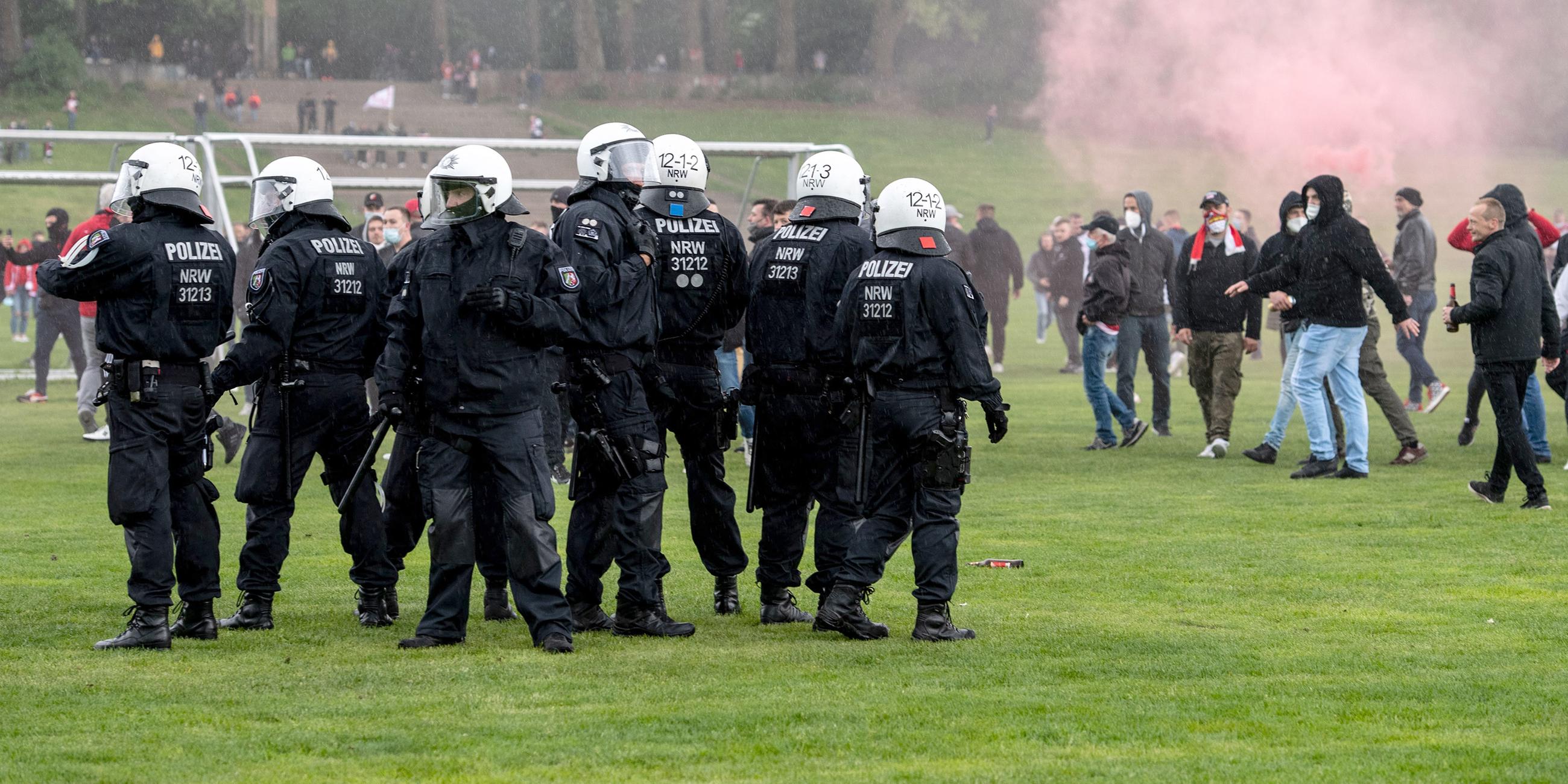 Polizisten und Fans des 1. FC Köln auf der Jahnwiese vor dem Stadion