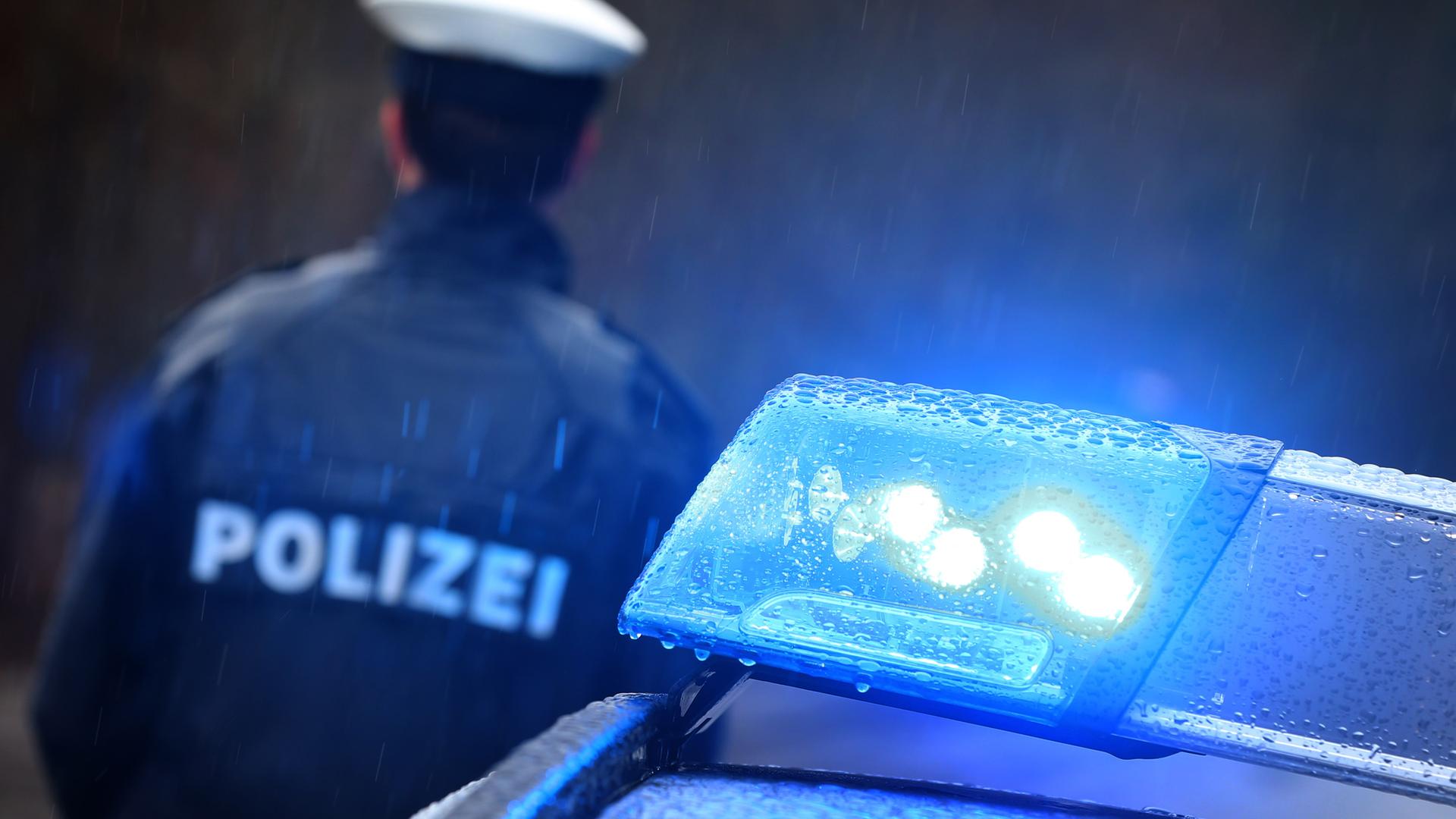 Polizist neben Blaulicht