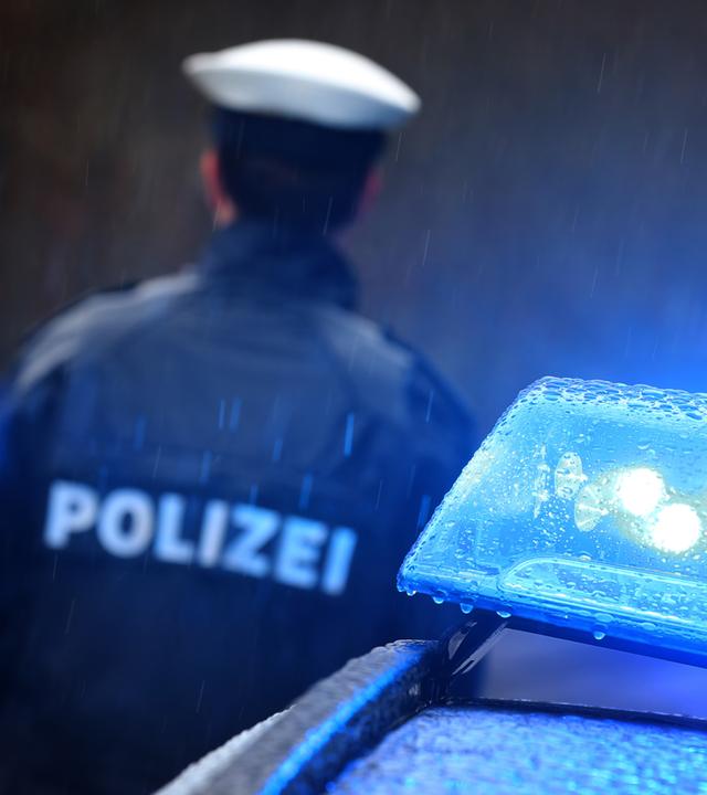 Polizist neben Blaulicht