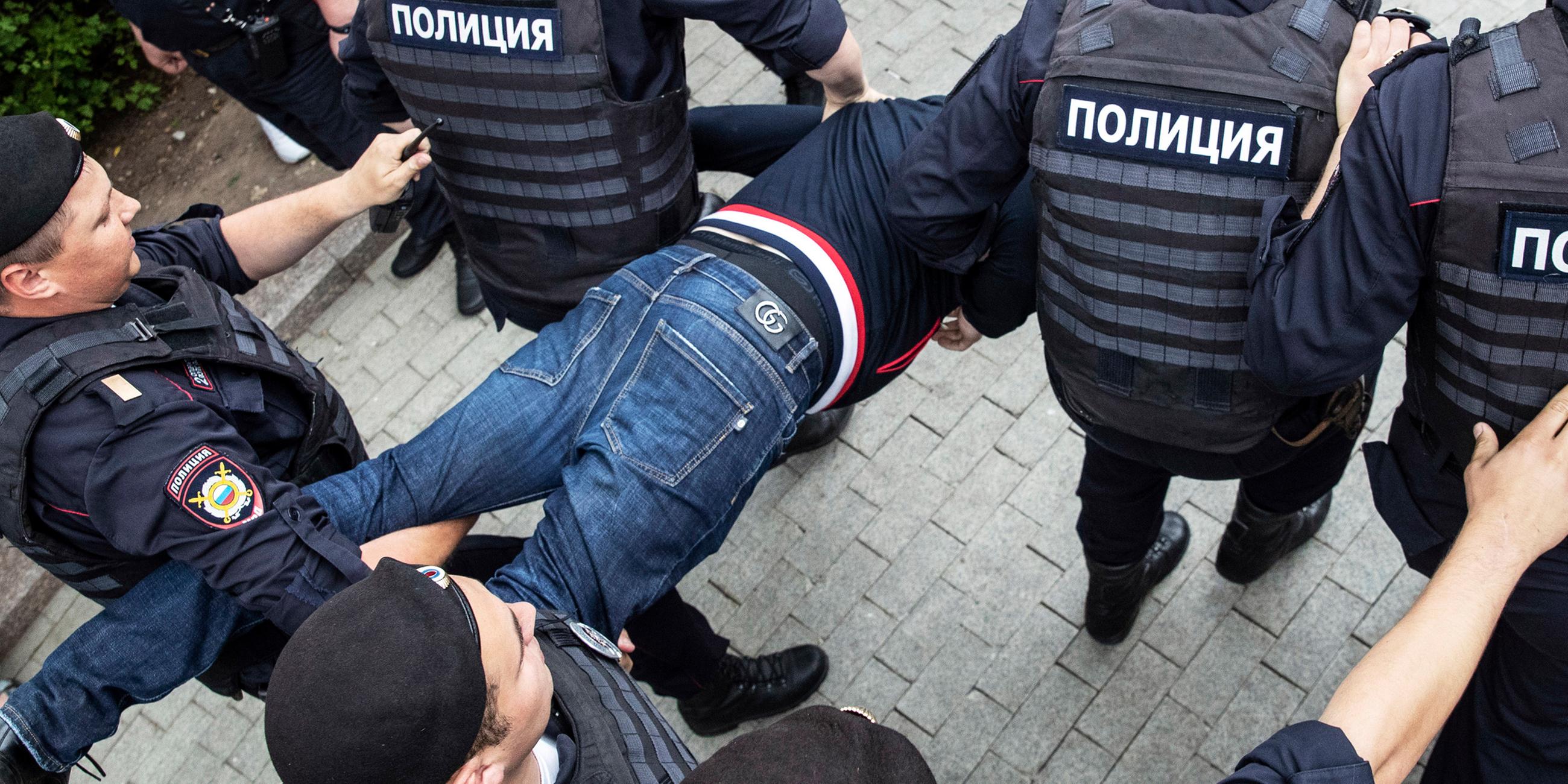 Polizisten tragen am 12.06.2019 in Moskau einen festgenommenen Demonstranten