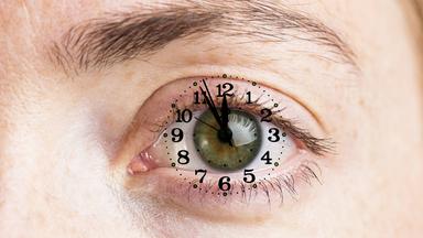 Geöffnetes Auge mit Ziffernblatt