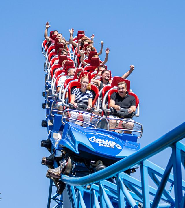 Kinder und Familien fahren Achterbahn und freuen sich