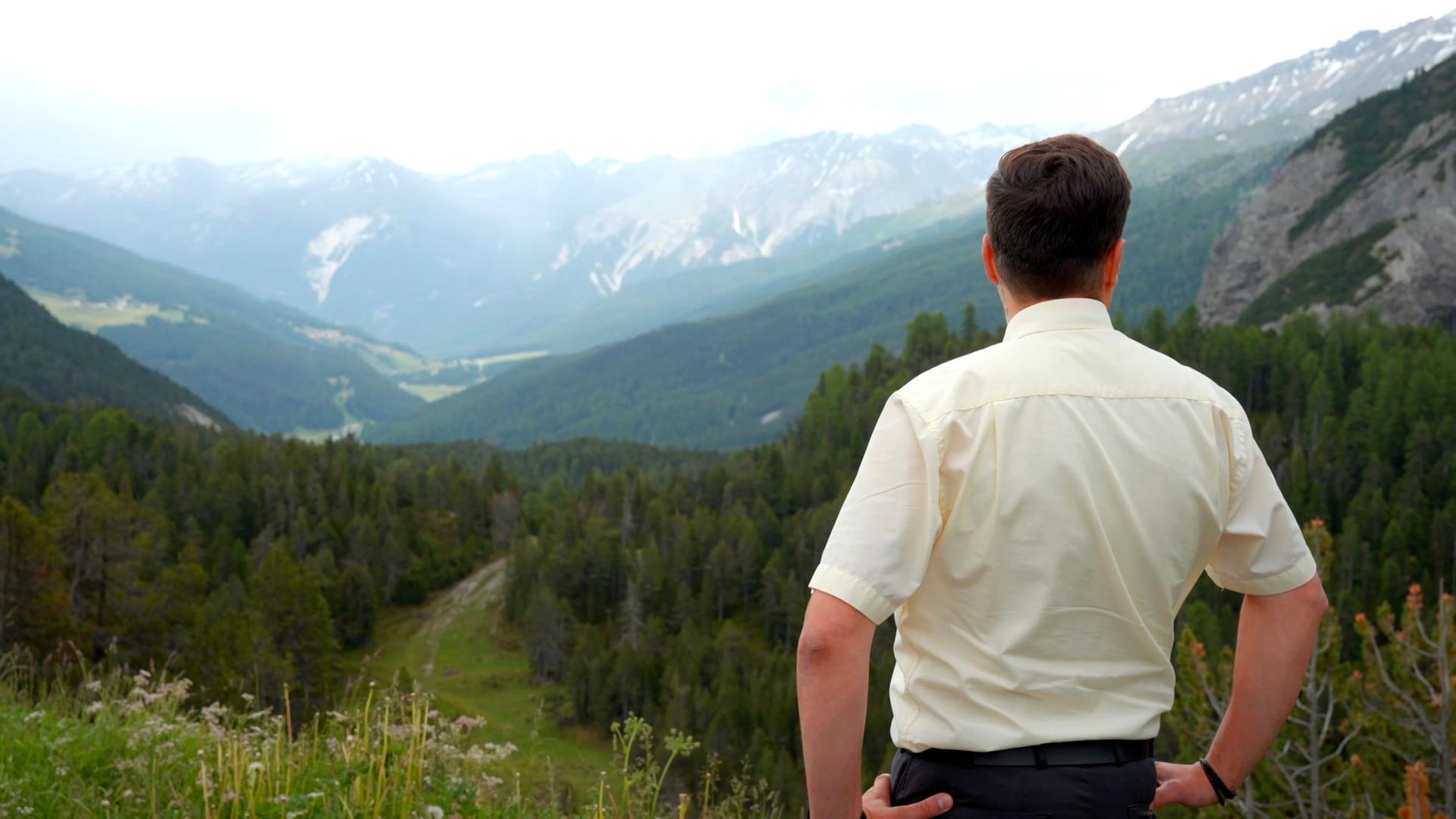 Mann von hinten blickt in Tal