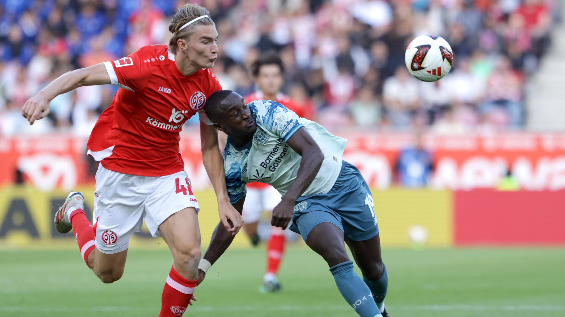Der Mainzer Innenverteidiger Kacper Potulski reißt seinen Gegenspieler Moussa Diaby im Zweikampf zu Boden
