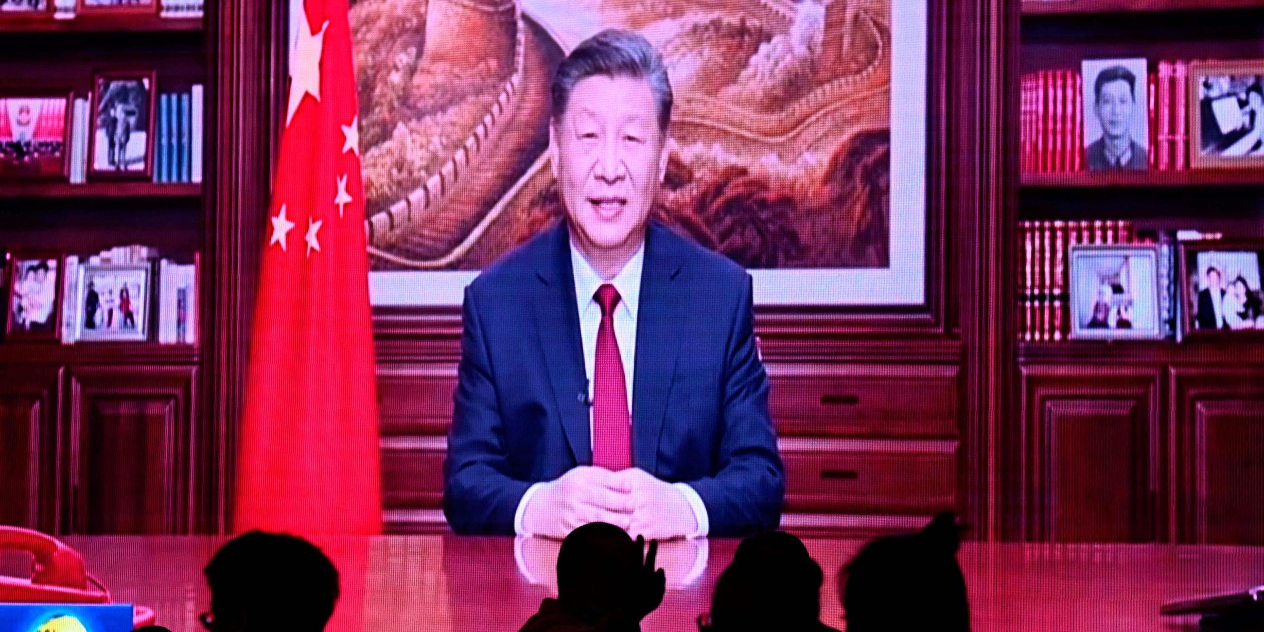 Menschen essen in einem Restaurant, während ein Bildschirm Chinas Präsident Xi Jinping bei seiner Neujahrsansprache in Peking am 31.12.2023 überträgt.