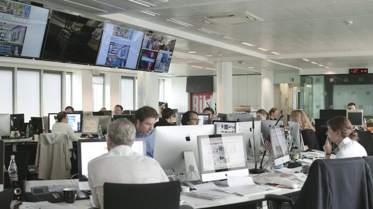 "AGGREGAT": Im Newsroom der BILD-Redaktion sitzen die Redakeurinnen und Redakteure vor ihren Bildschirmen.