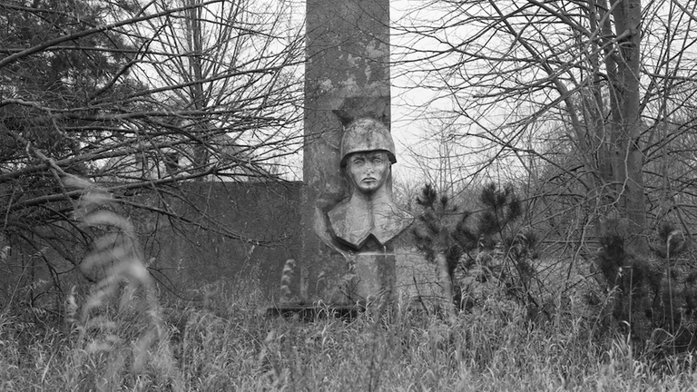 "Heimat ist ein Raum aus Zeit" (3sat): Soldat als stilisierte Sphinxstatue in einem Wald (Schwarzweißfoto)