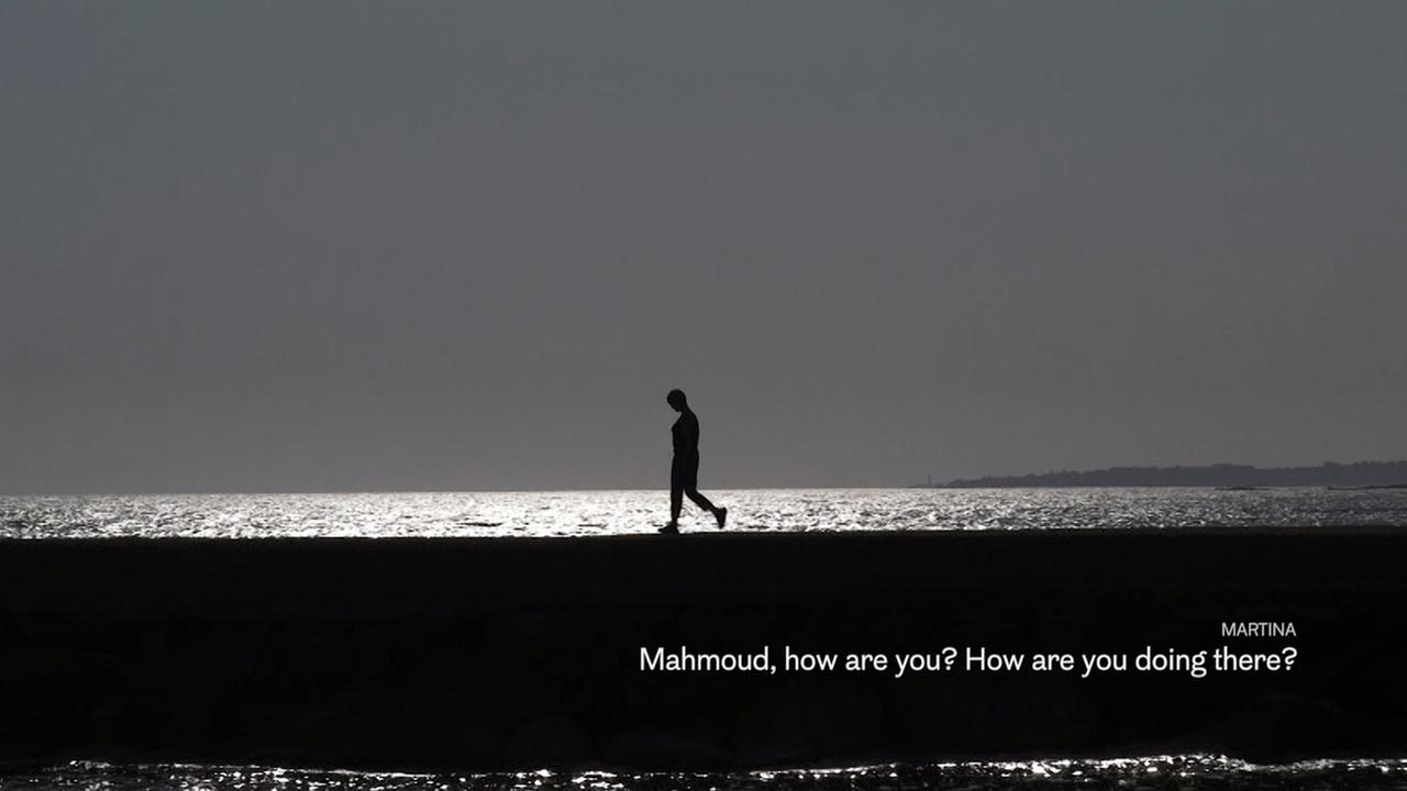 My home, in Libya:  Mahmoud läuft nachts an einem Strand entlang: Rechts unten im Bild Martinas Chat-Nachricht 'Mahmoud how are you? How are you doing there?