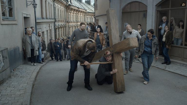 "Über die Unendlichkeit" (ARTE): Filmszene mit Kreuz-schleppenden Priester (Martin Serner). 