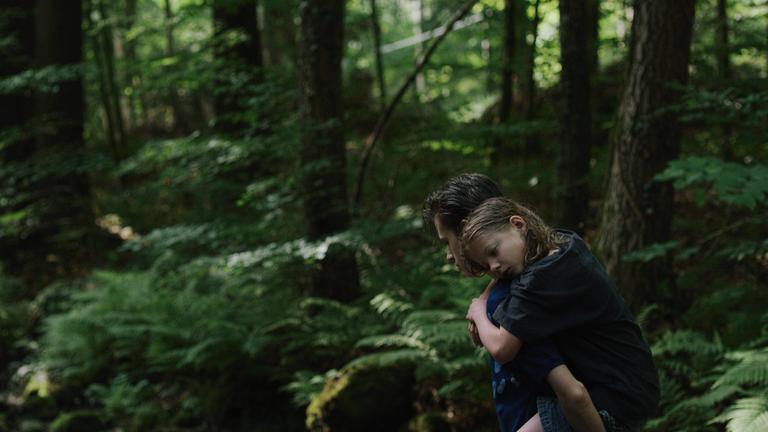 "Ich war zuhause, aber": Der 13-jährige Phillip (Jakob Lassalle) trägt seine kleine Schwester Flo (Clara Möller) auf dem Rücken durch den Wald.