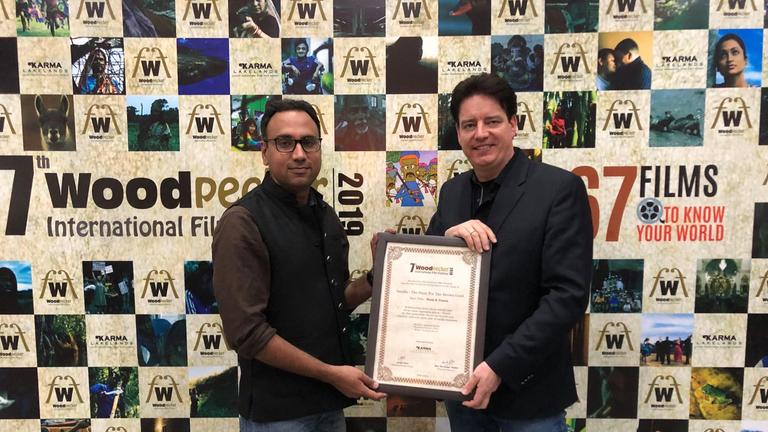 Woodpecker International Festival 2019 in Delhi: Festivalleiter Rao Narender Yadav (links) und ZDF-Autor Andreas Ewels präsentieren die Preisurkunde für "planet e.: Vanille - Die Jagd nach denmm braunen Gold"