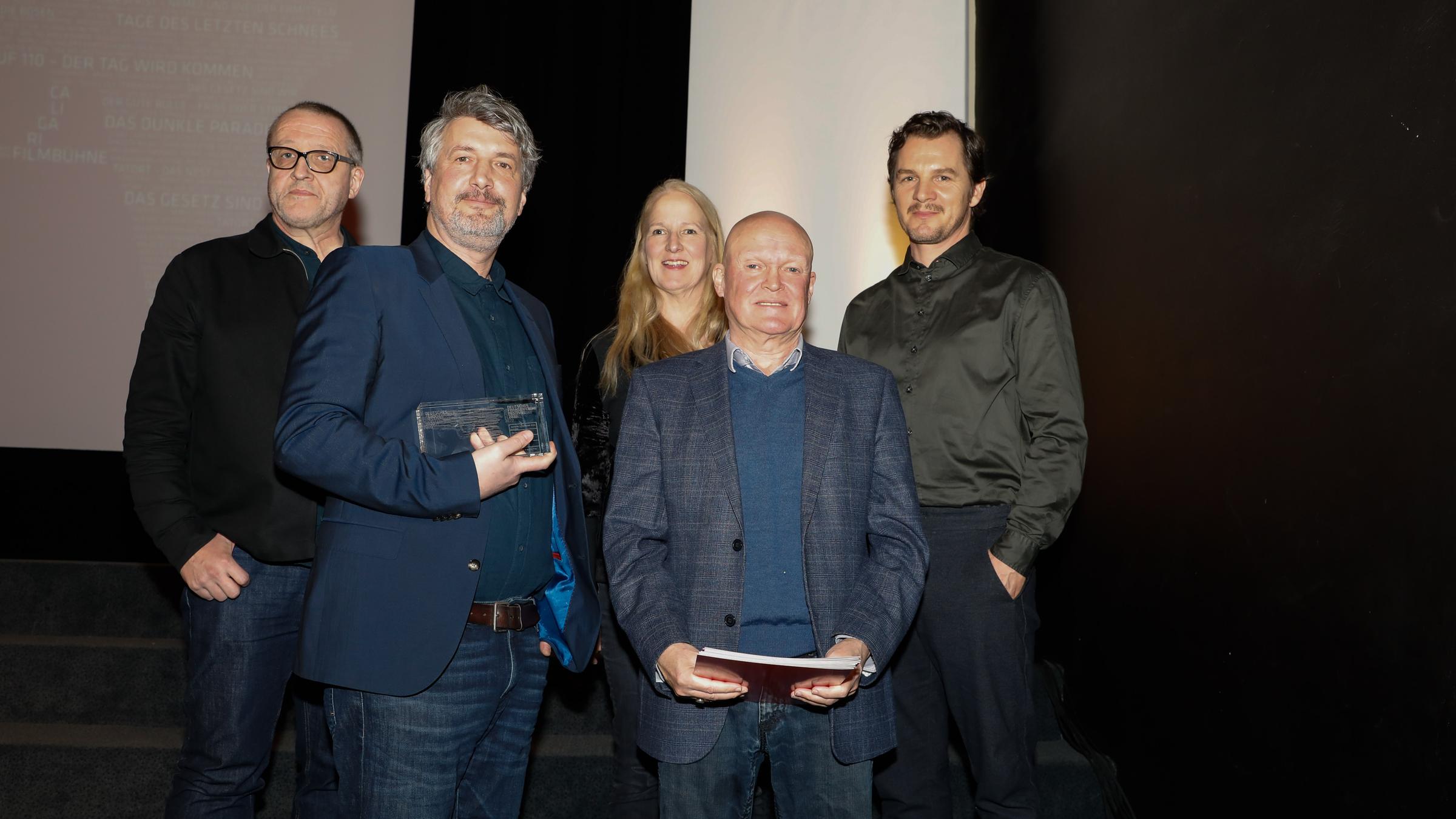 Deutscher Fernsehkrimipreis 2020, Wiesbaden: Produzent André Zoch und Günther van Endert freuen sich über den FernsehKrimi-Preis 2020 für "Das Gesetz sind wir". Im Hintergrund die Jury Max Annas, Belinde Ruth Stieve und Felix Klare.