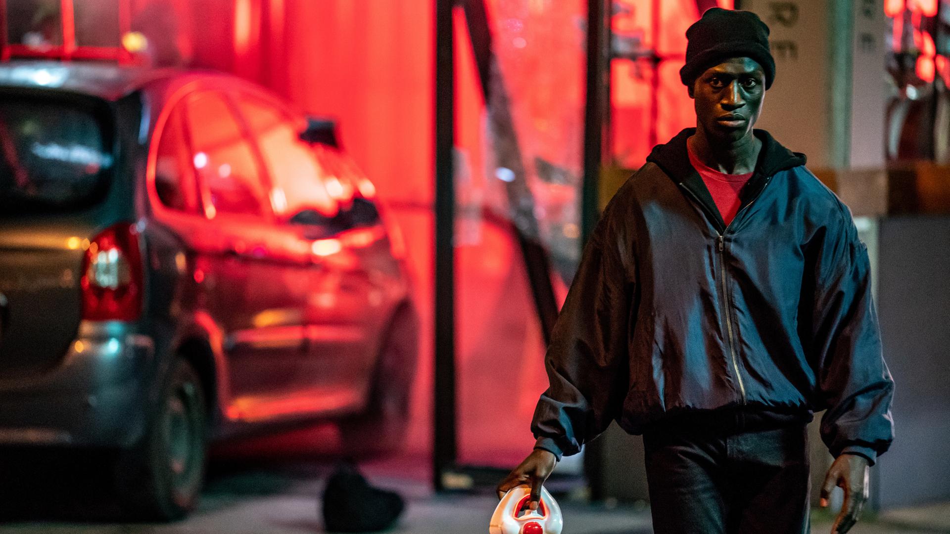 „Berlin Alexanderplatz“: Francis (Welket Bungué) läuft mit einer Clown-Maske in der Hand durch die nächtlichen Straßen von Berlin.