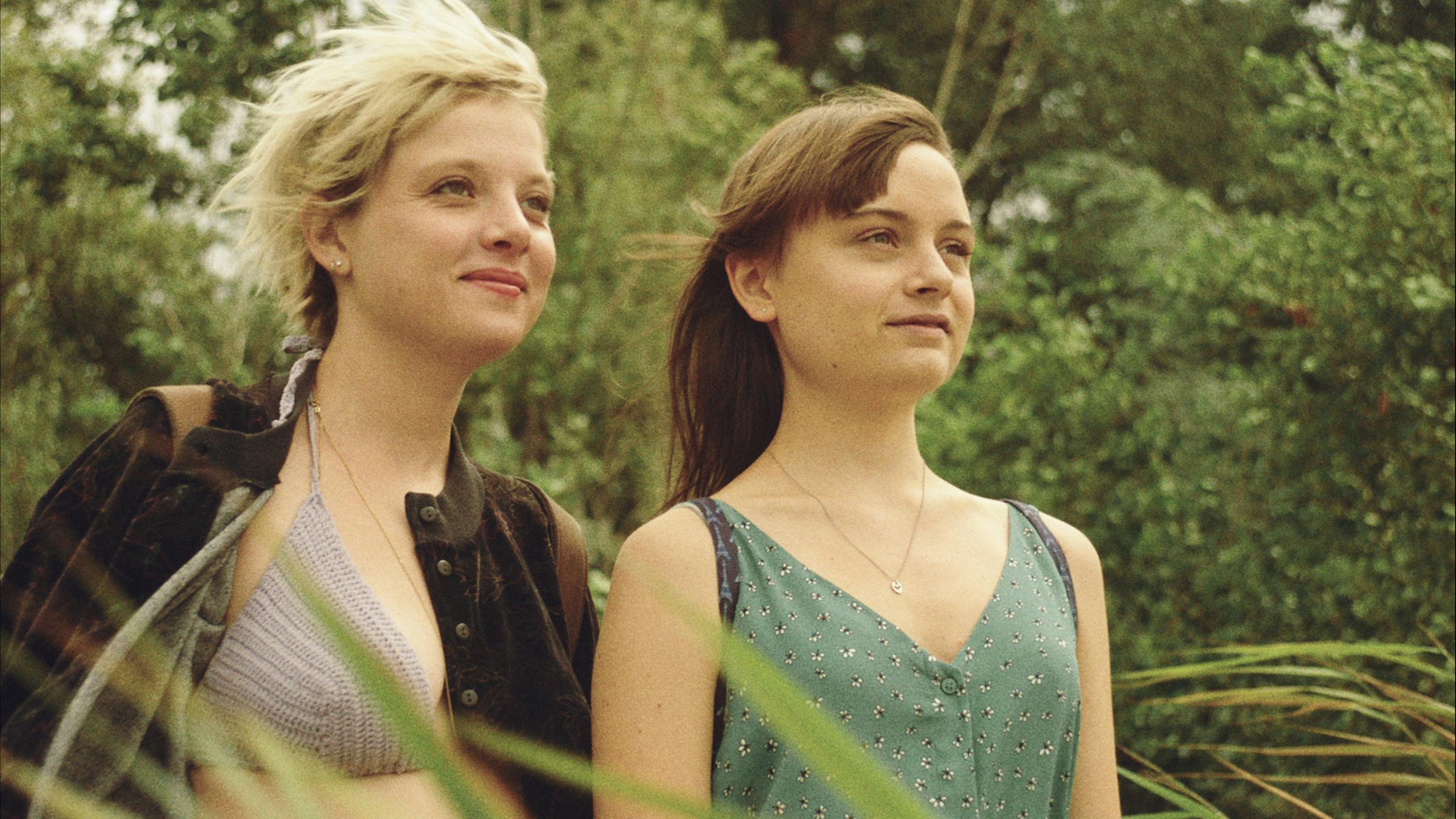 "Kokon": Romy (Jella Haase) und Nora (Lena Urzendowsky) stehen nebeinander am Waldrand und blicken in die gleiche Richtung.