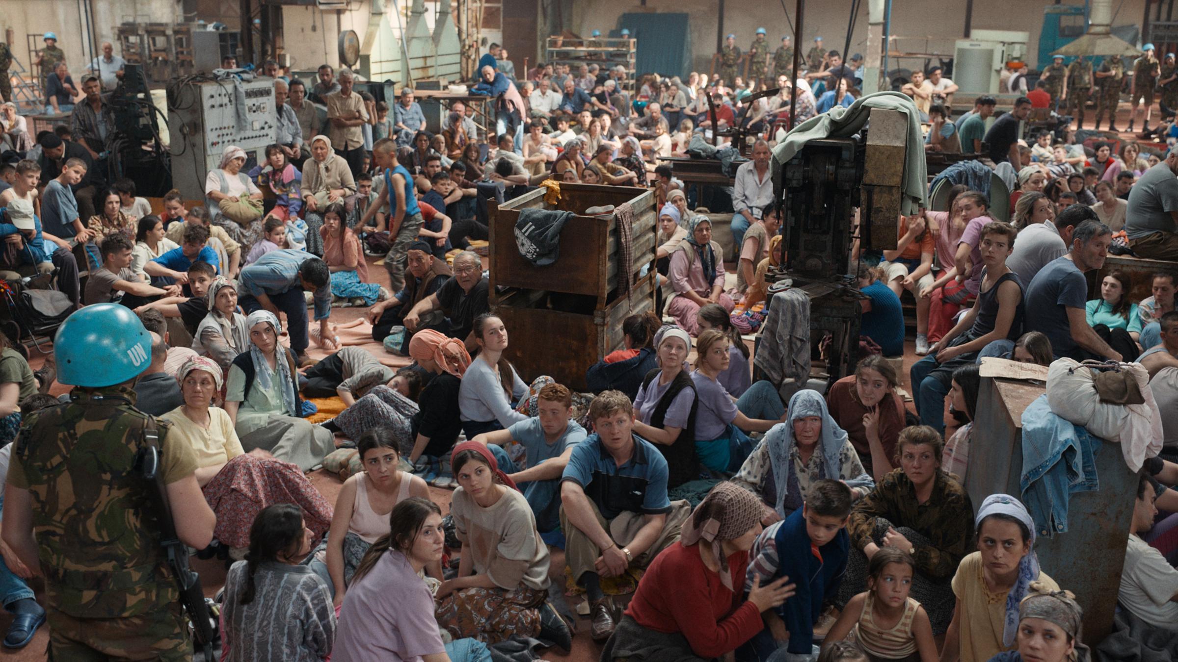 "Quo vadis, Aida?": Die muslimische Bevölkerung Srebrenicas hat sich in der UN-Blauhelm-Schutzzone in scheinbare Sicherheit gebracht. Viele Menschen sitzen in einer großen Halle auf dem Fußboden zwischen Kisten und anderen Gerätschaften. Im Vordergrund links steht ein Blauhelm-Soldat.