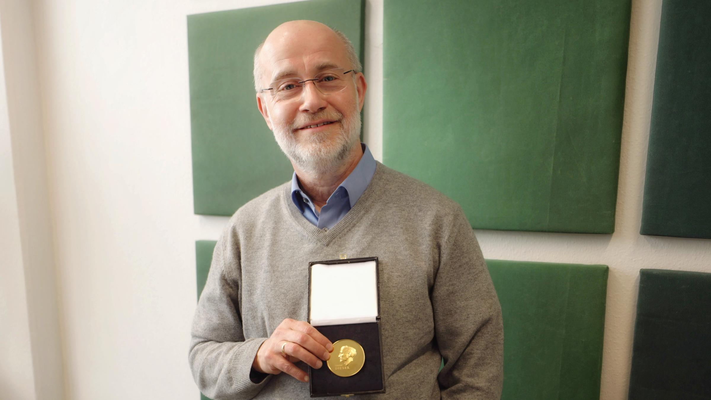Harald Lesch präsentiert die Rudolf-Diesel-Medaille, mit der "Terra X, Lesch & Co" ausgezeichnet wurde. 