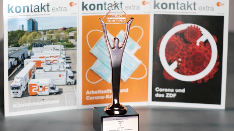 Die drei ausgezeichneten Corona-Sonderausgaben von "Kontakt" (in kleinster Auflage nachdgedruckt); davor die Preistrophäe