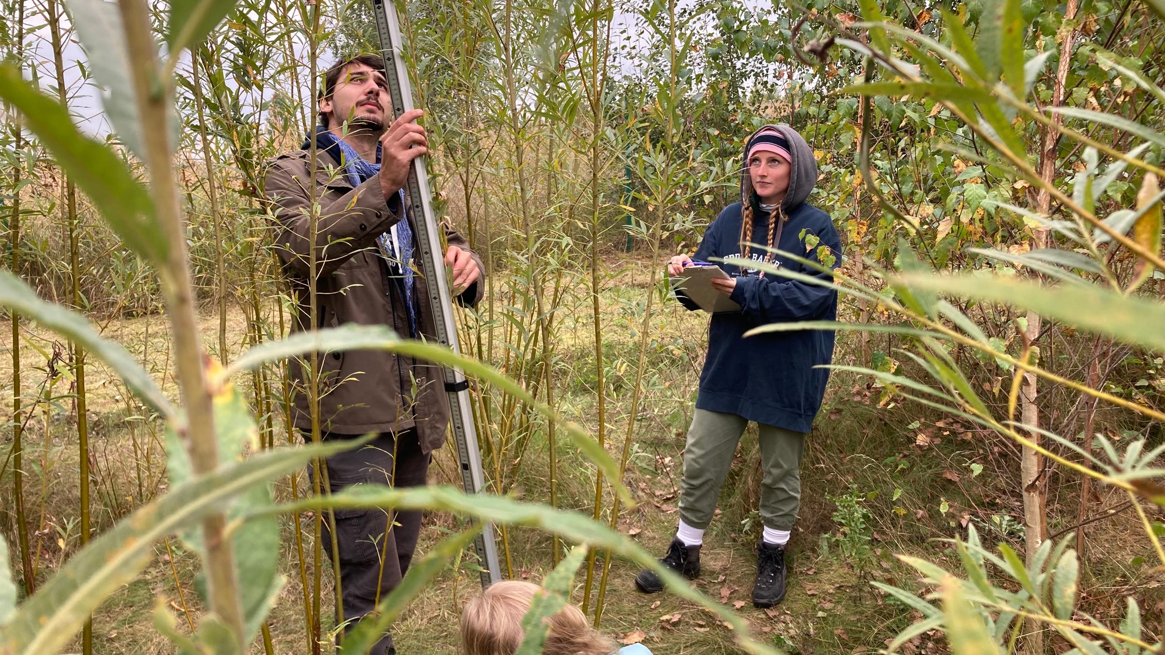 "plan b: Boden gut machen": Eine junge Forscherin und ein junger Forscher messen die Qualität des Bodens im ehemaligen Uranabbaugebiet Ronneburg.