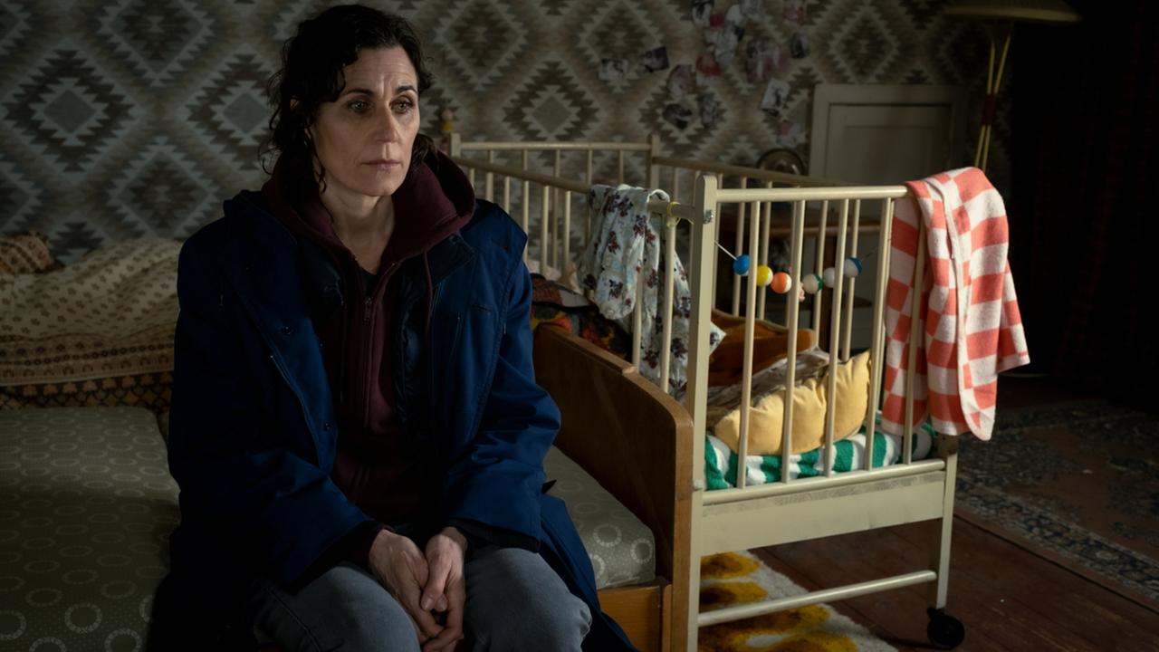 Hauptkommissarin Maria Voss (Nina Kunzendorf) sitzt in ihrem alten Schlafzimmmer auf der Bettkante. Links von ihr steht ein Kinderbett.