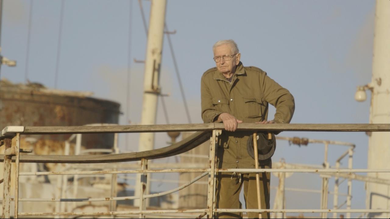 "Non-Aligned: Scenes from the Labudovic Reels"(arte): Kameramann Stevan Labudović steht an der Reling eines Schiffes und blickt hinunter. In der linken Hand hält er einen Hut.