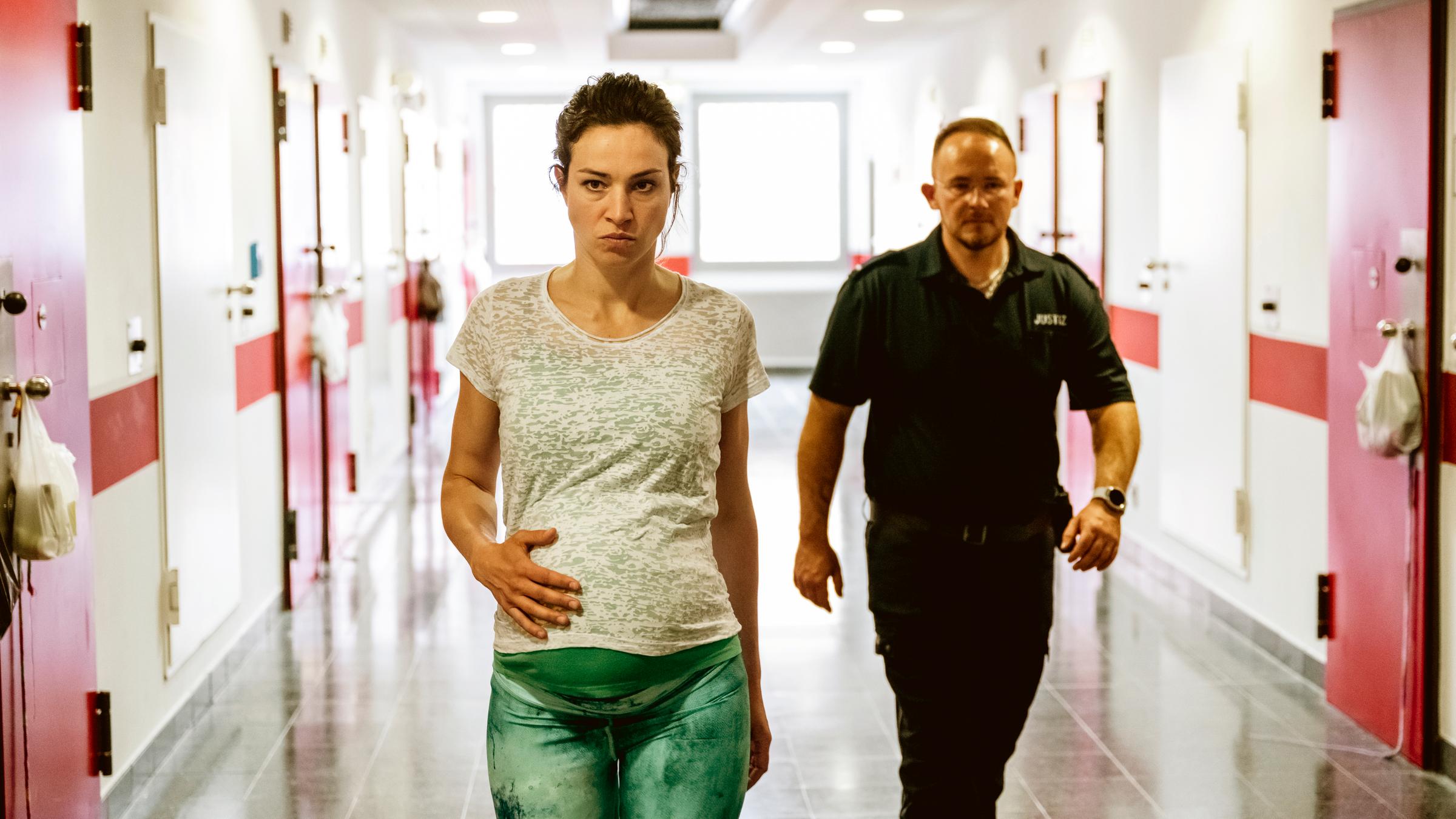 "Monster im Kopf": Die hochwangere Sandra (Franziska Hartmann) läuft in Begleitung eines Gefängnisaufsehers über den Zellenflur eines Gefängnisses