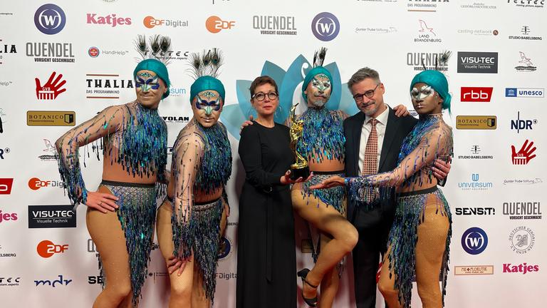 Verleihung Della Award in Potsdam, 11.11.2023: Nicola Foltys (Leiterin Abteilung Barrierefreiheit) und Marcel Ehrlich (ZDF Digital) inmitten der Gebärdensprachdolmetscher, die in den Produktionen oft verkleidet gebärden (siehe nächstes Bild). 
