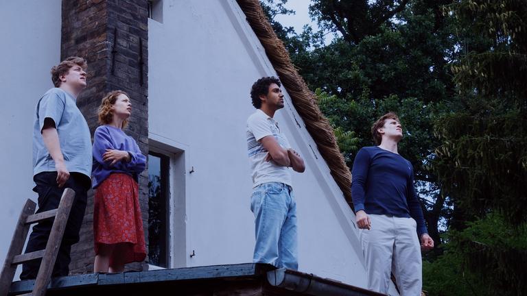 Leon (Thomas Schubert, l.), Nadja (Paula Beer), Felix (Langston Uibel, 2.v.r.) und Devid (Enno Trebs, r.) stehen auf dem Vordach eines Ferienhauses und blicken in den Himmel