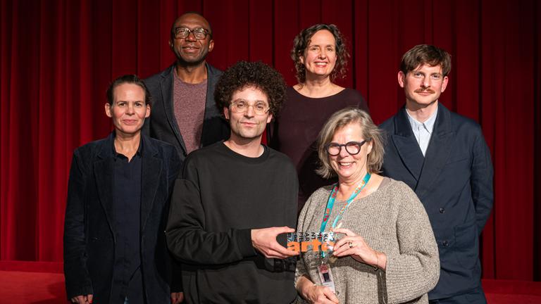 Vergabe ARTE-Dokumentarfilmpreis auf der Duisburger Filmwoche (9. November 2024): Preisträger Daniel Fill (Mitte) mit der ARTE-Jury Stefanie Gaus, Enoka Ayemba, Christiane Büchner. Rechts: Festivalleiter Alexander Scholz.
