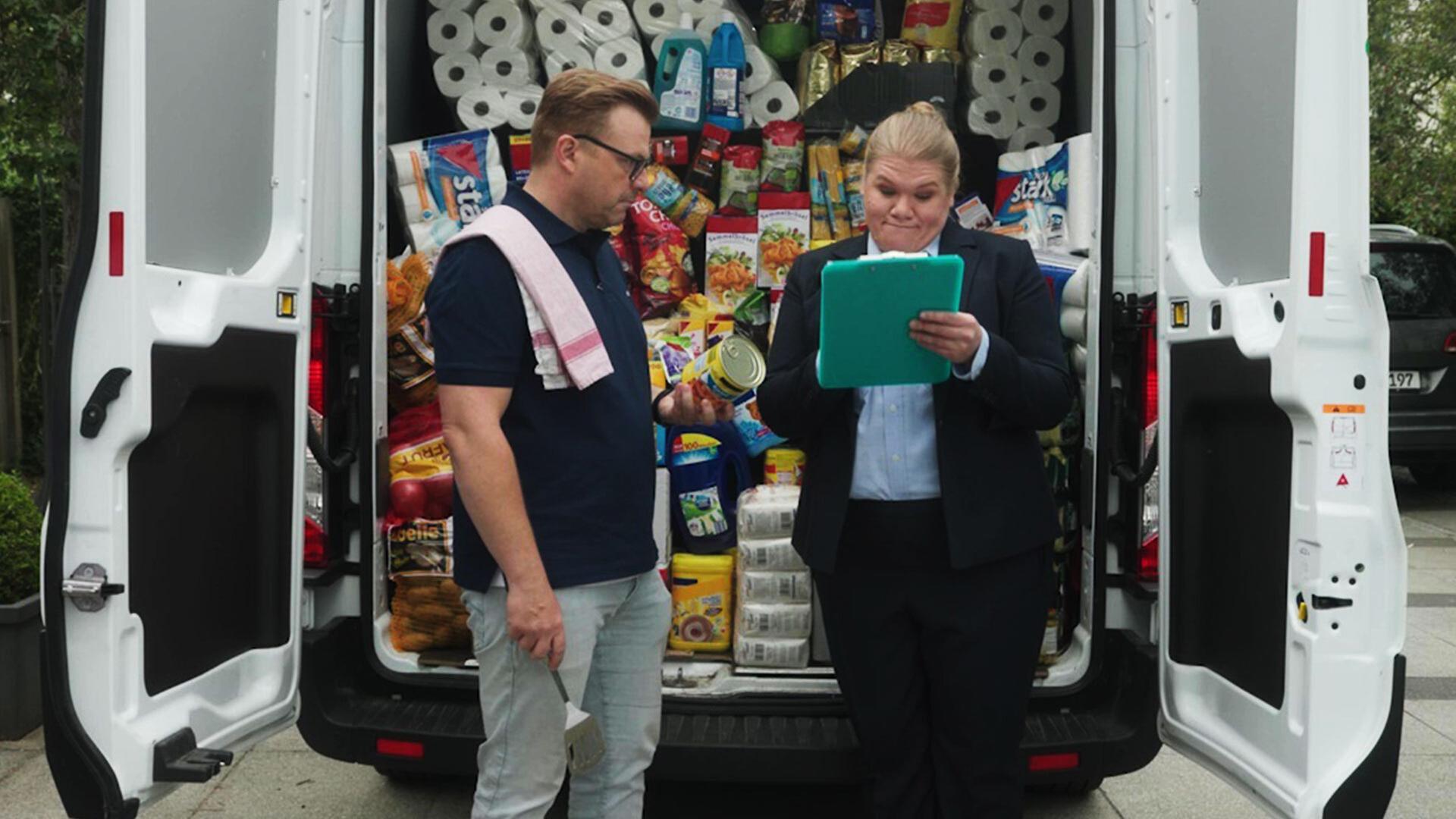 Gisa Flake und Alexander Wipprecht stehen vor einem vollgepackten Lieferwagen mit Lebensmitteln