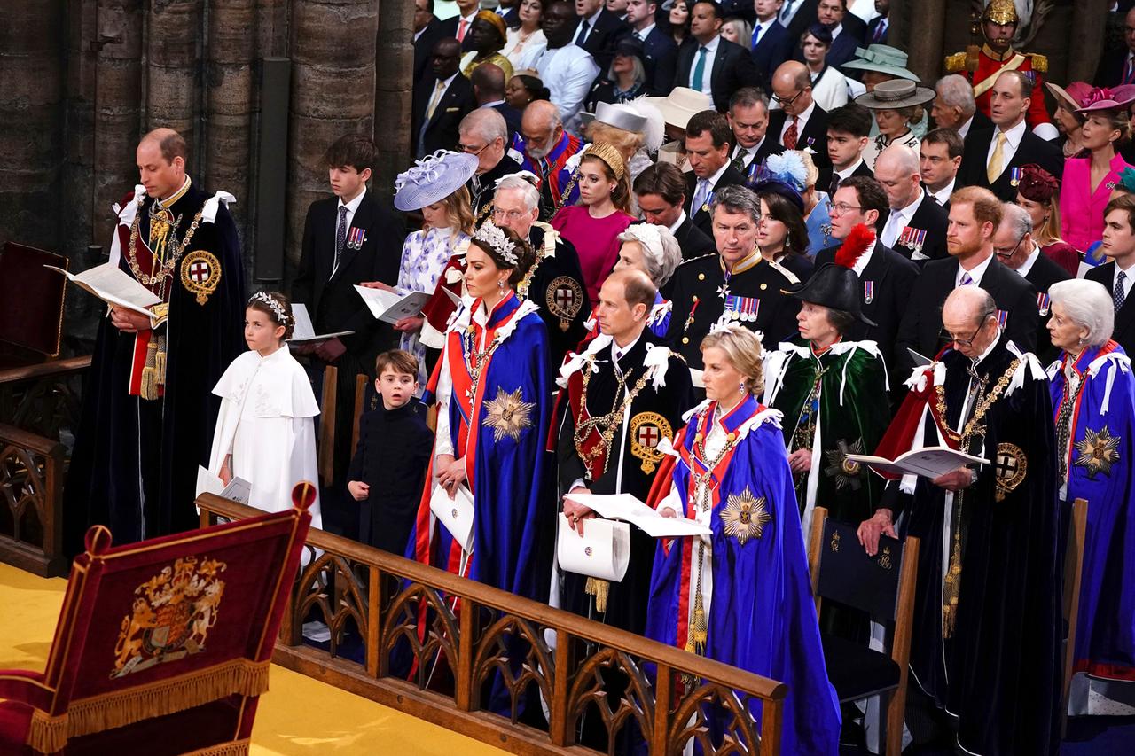 Prinz Harry sitzt in der Westminster Abbey während der Krönungsfeier seines Vaters in der dritten Reihe. In der ersten Reihe sitzen von links nach rechts: Prinz William, Prinzessin Charlotte, Prinz Louis sowie Kate und Edward.