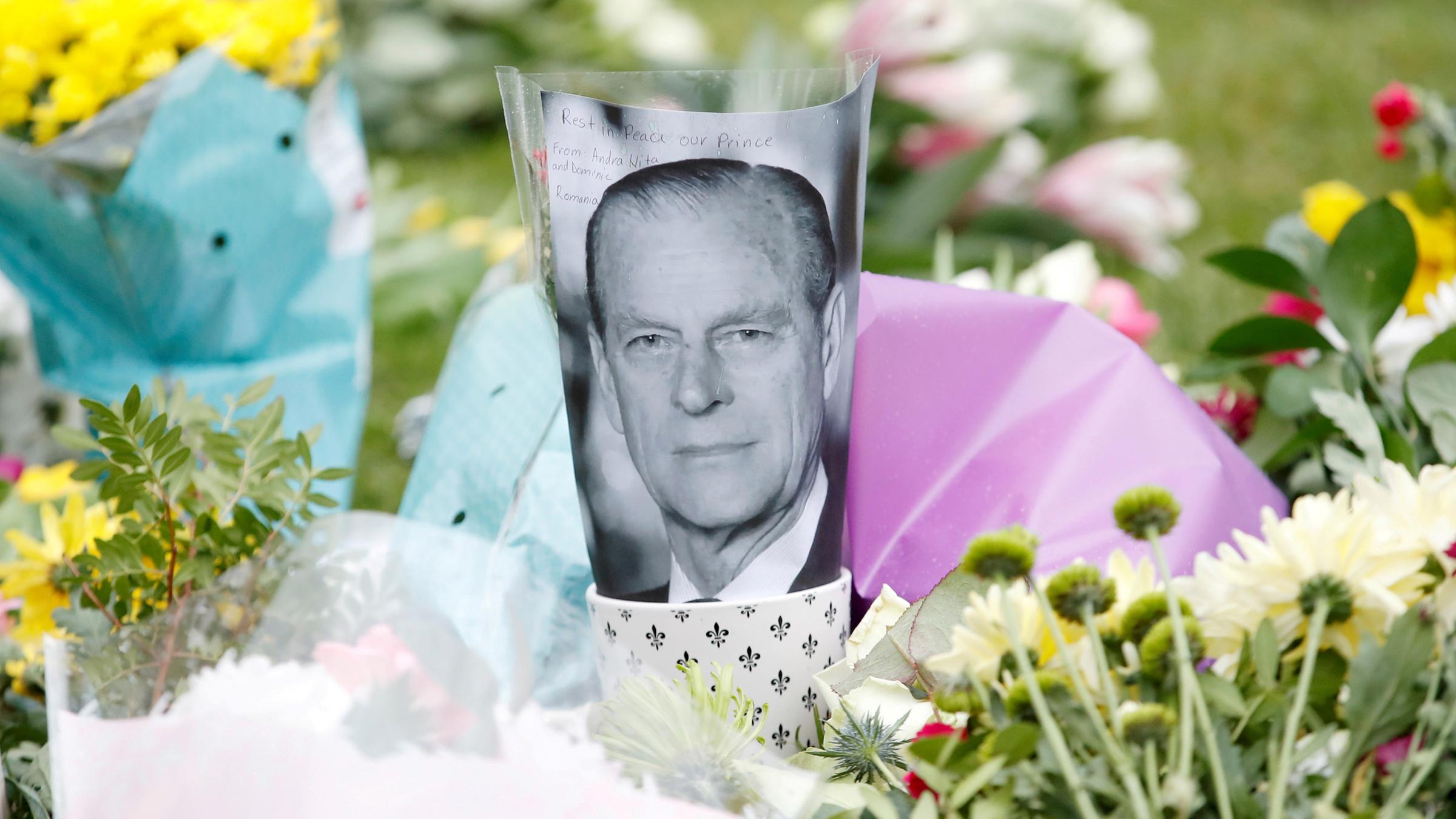 Ein Bild vom verstorbenen Prinz Philip  umringt von Blumen am 10.04.2021 in London