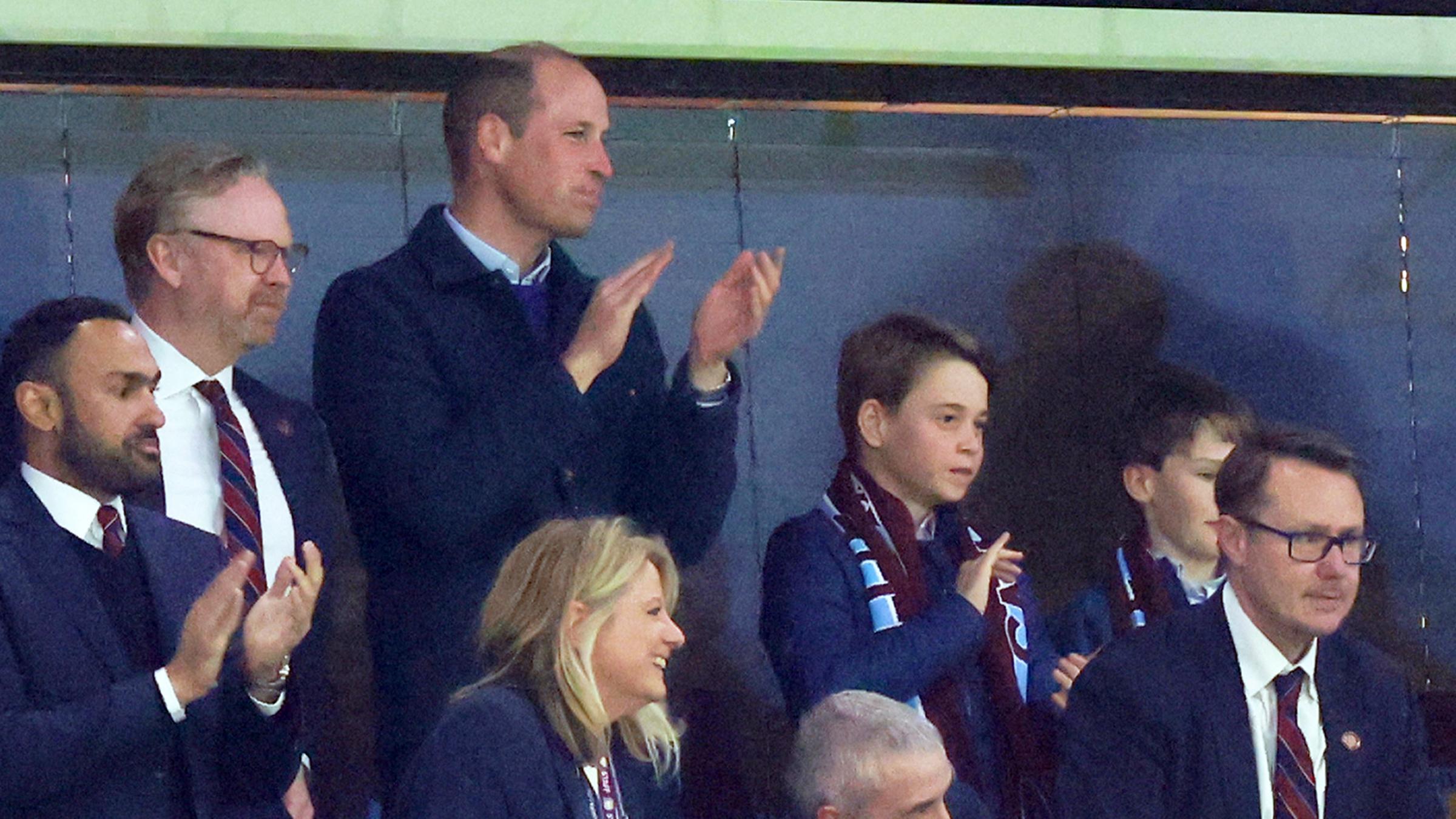Prinz William mit Sohn George stehend auf der Tribüne während eines Fussballspiels
