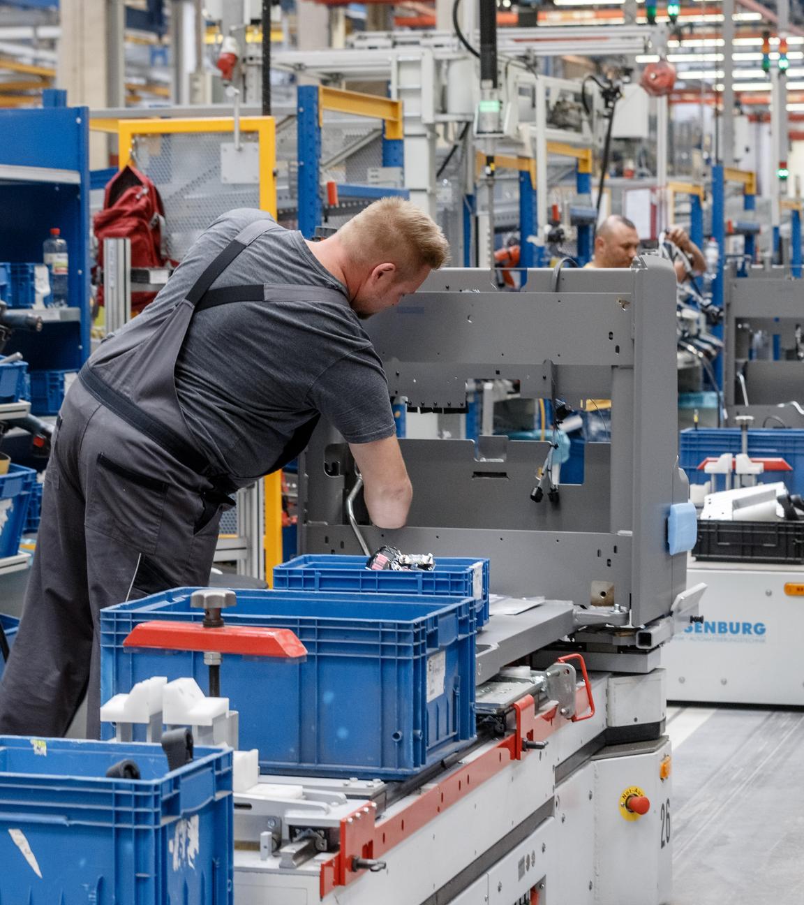 Ein Mitarbeiter in Arbeitskleidung arbeitet an einer Maschine im Gabelstaplerwerk Norderstedt.