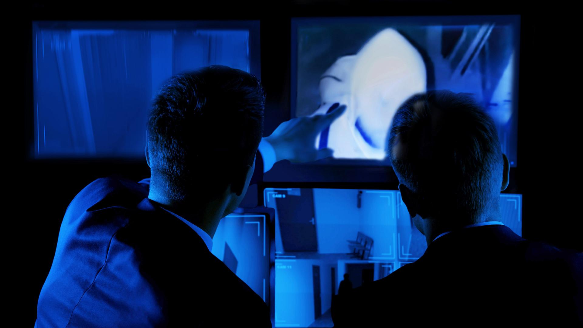 Sicherheitsdienst betrachtet Aufnahmen von Überwachungskameras