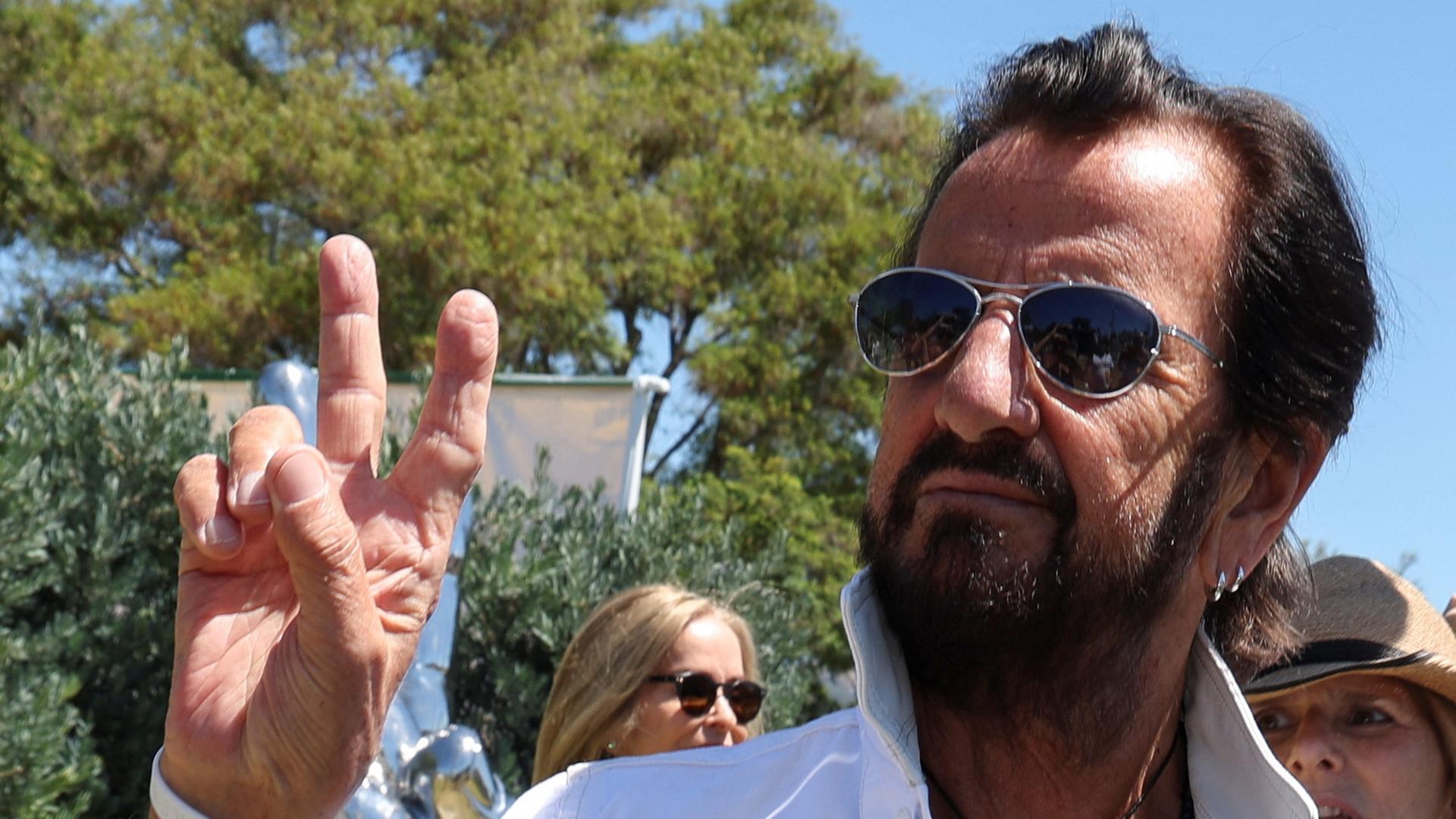 Ringo Starr zeigt das Peace-Zeichen