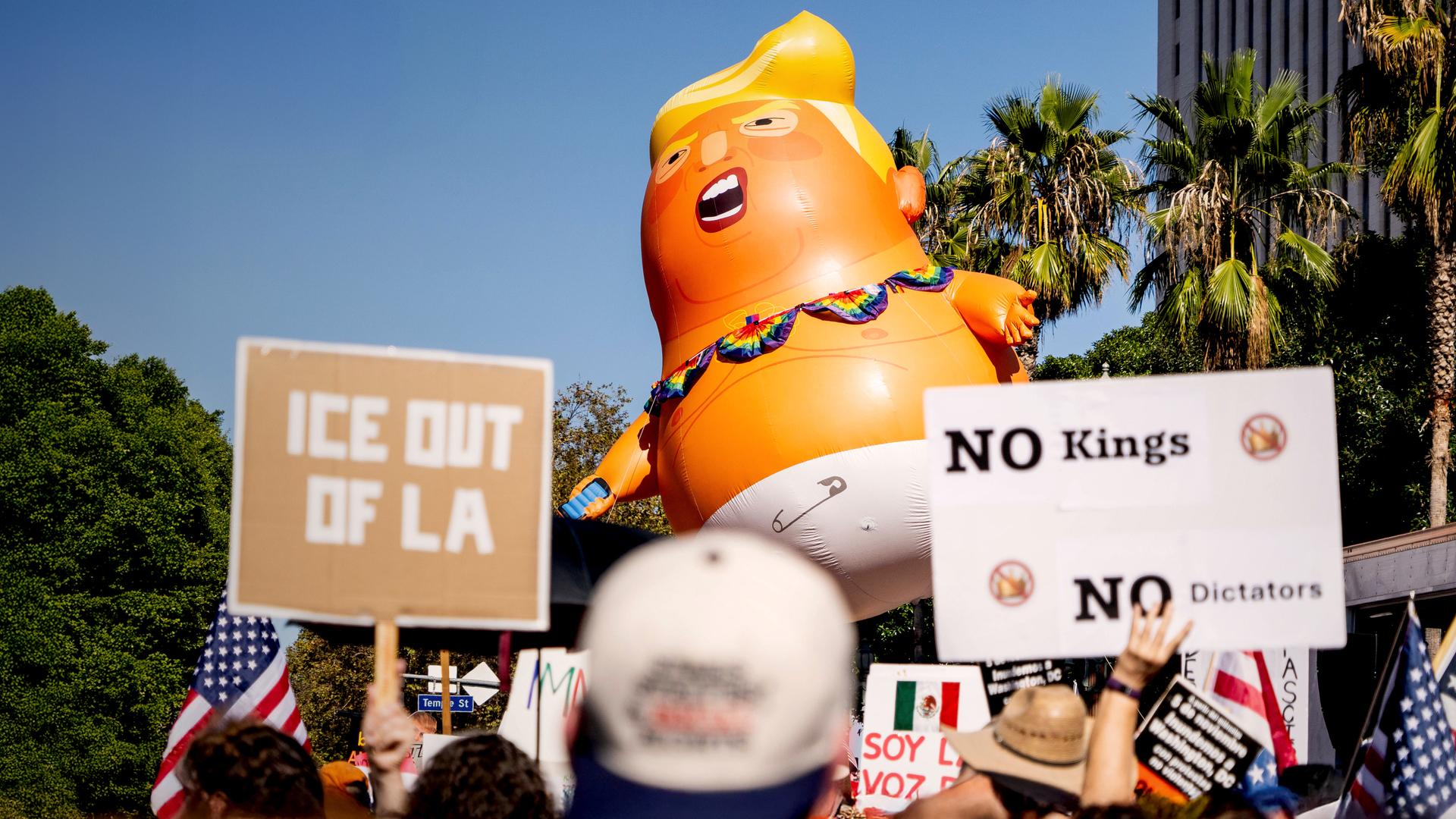 Demonstration gegen Trump in L.A., in der Mitte ein aufgeblasener Ballon mit Trump in Windeln - Motiv. Rechts vorne eine Schild mit der Aufschrift „No