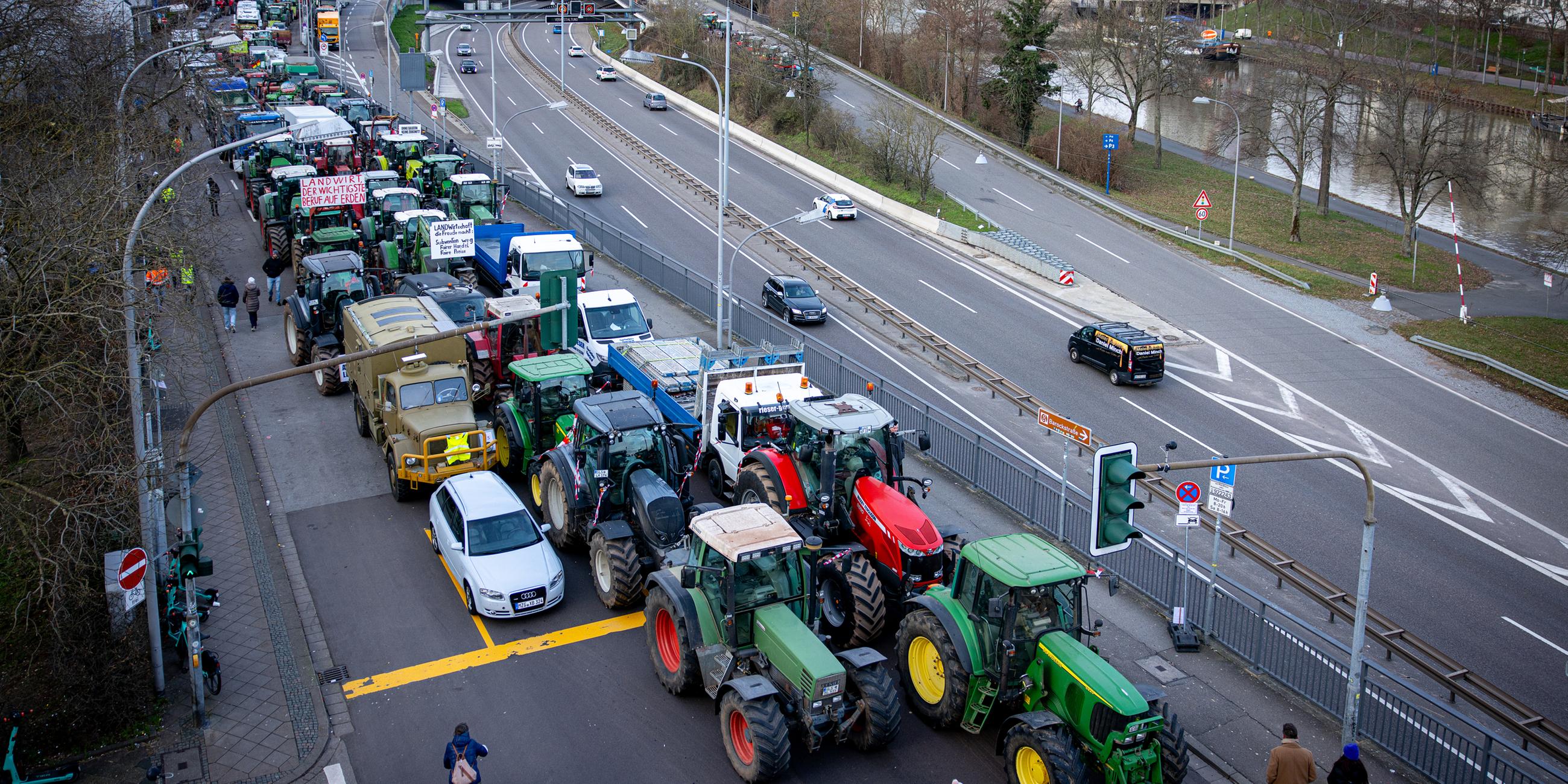 Saarland, Saarbrücken: Traktoren stehen am Rande der Bauernproteste auf einer Straße.